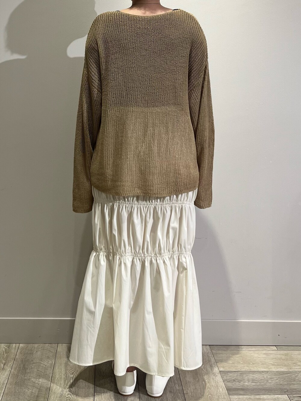 ベージュ系のニット/セーター、ホワイト系のスカート、グリーン系のブルゾンを着用したレディースの春コーディネートの4枚目の写真