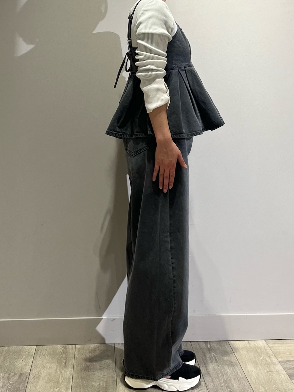 グレー系のキャミソール、グレー系のデニムパンツ、ホワイト系のニット/セーターを着用したレディースの春コーディネートの3枚目の写真