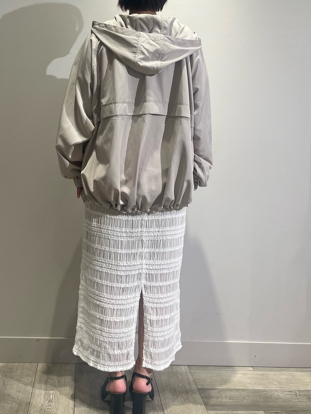 ホワイト系のスカート、ベージュ系のブルゾンを着用したレディースの夏コーディネートの4枚目の写真