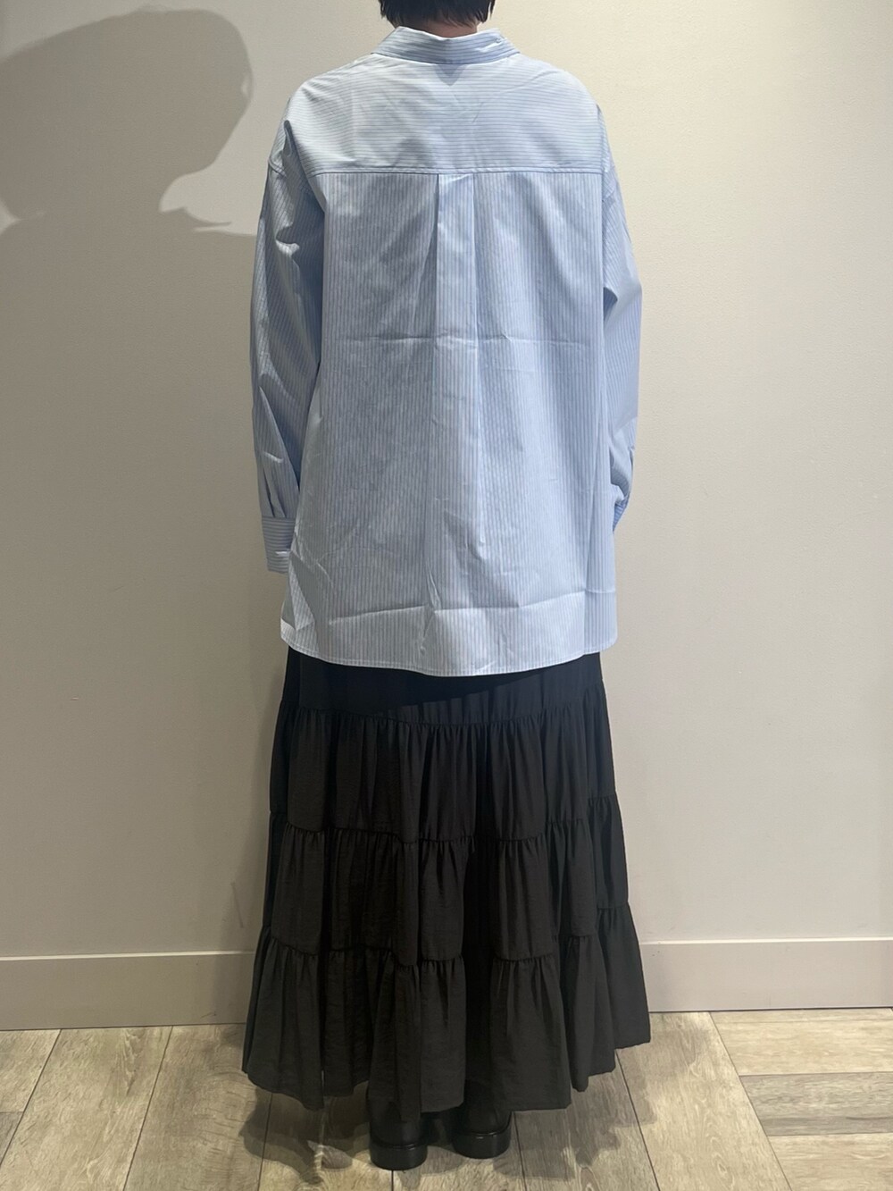 グレー系のテーラードジャケット、ホワイト系のニット/セーター、グレー系のスカートを着用したレディースの冬コーディネートの4枚目の写真