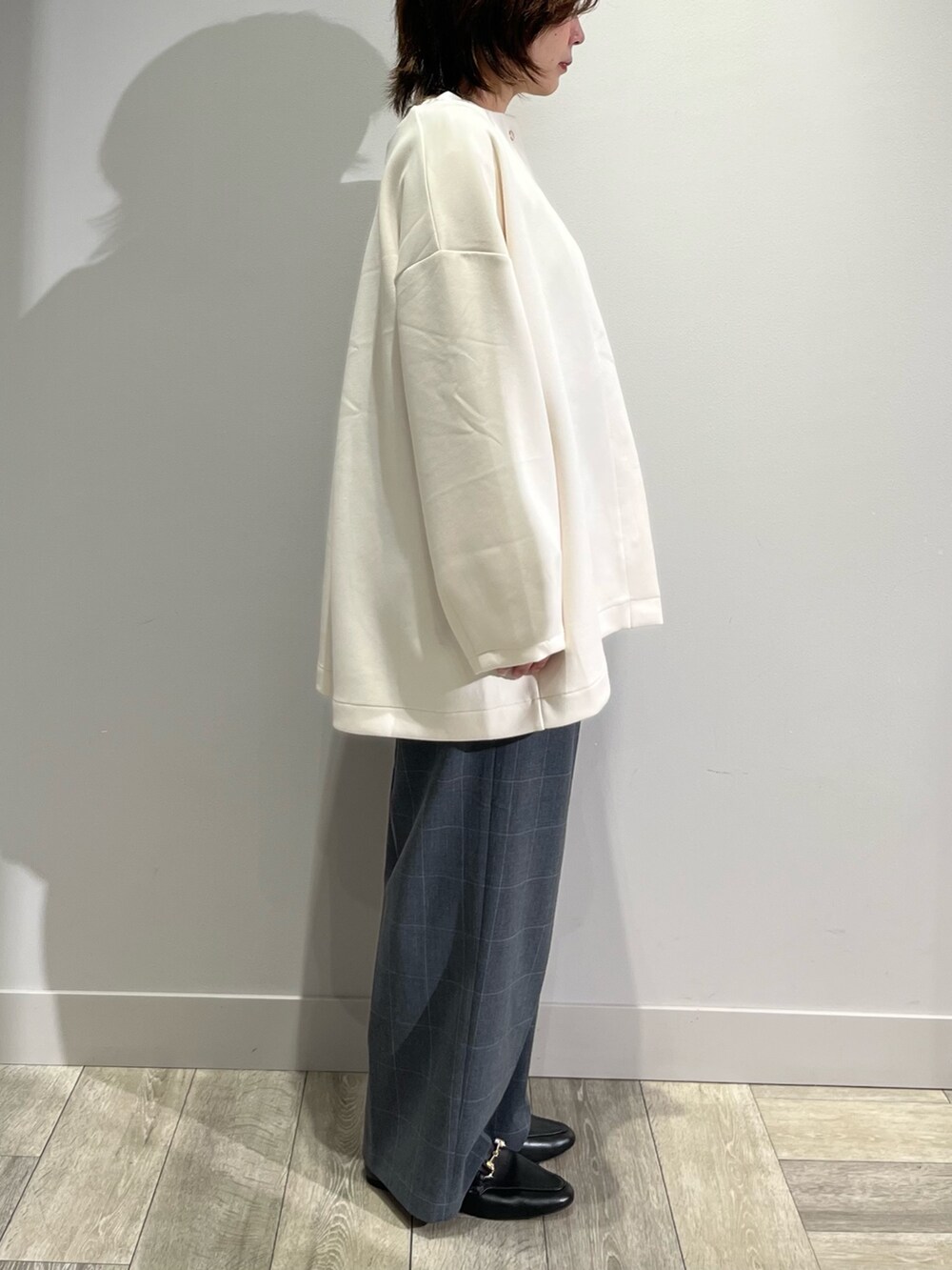 ホワイト系のノーカラーコート、グレー系のその他パンツ、ホワイト系のTシャツ/カットソーを着用したレディースの秋コーディネートの4枚目の写真