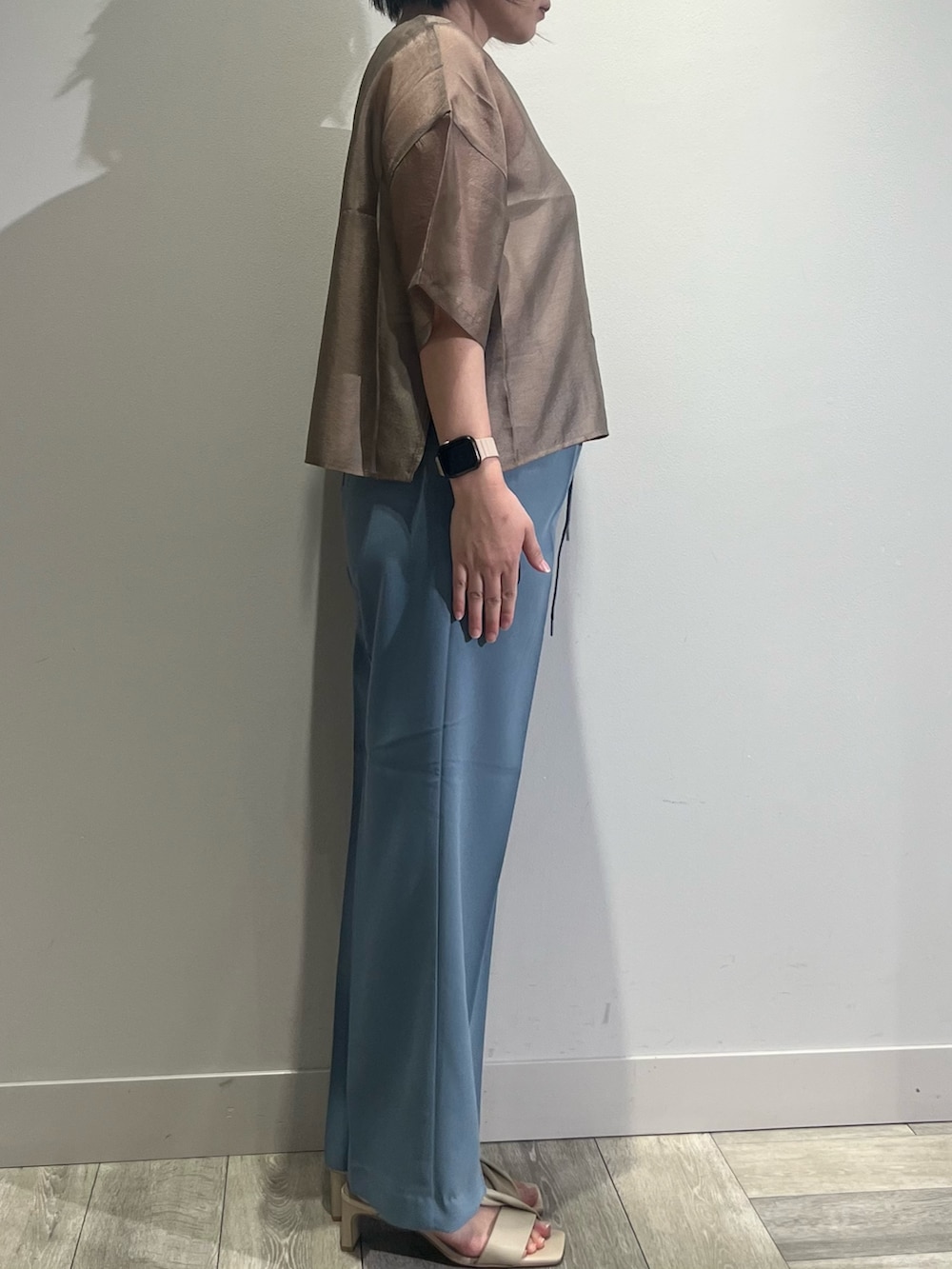 ブラウン系のシャツ/ブラウス、ホワイト系のタンクトップ、ブルー系のスラックスを着用したレディースの春コーディネートの3枚目の写真