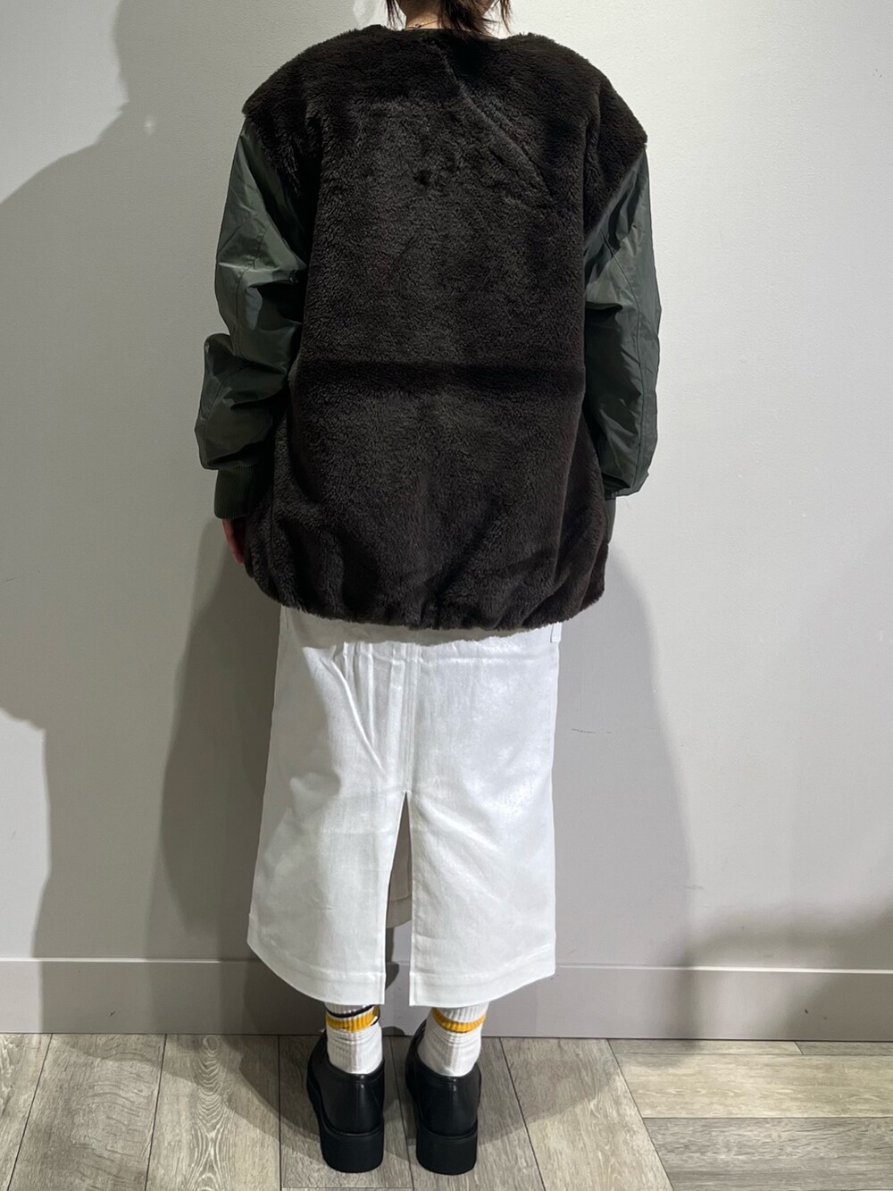 グリーン系のブルゾン、グレー系のTシャツ/カットソー、シルバー系のスカートを着用したレディースの秋コーディネートの4枚目の写真