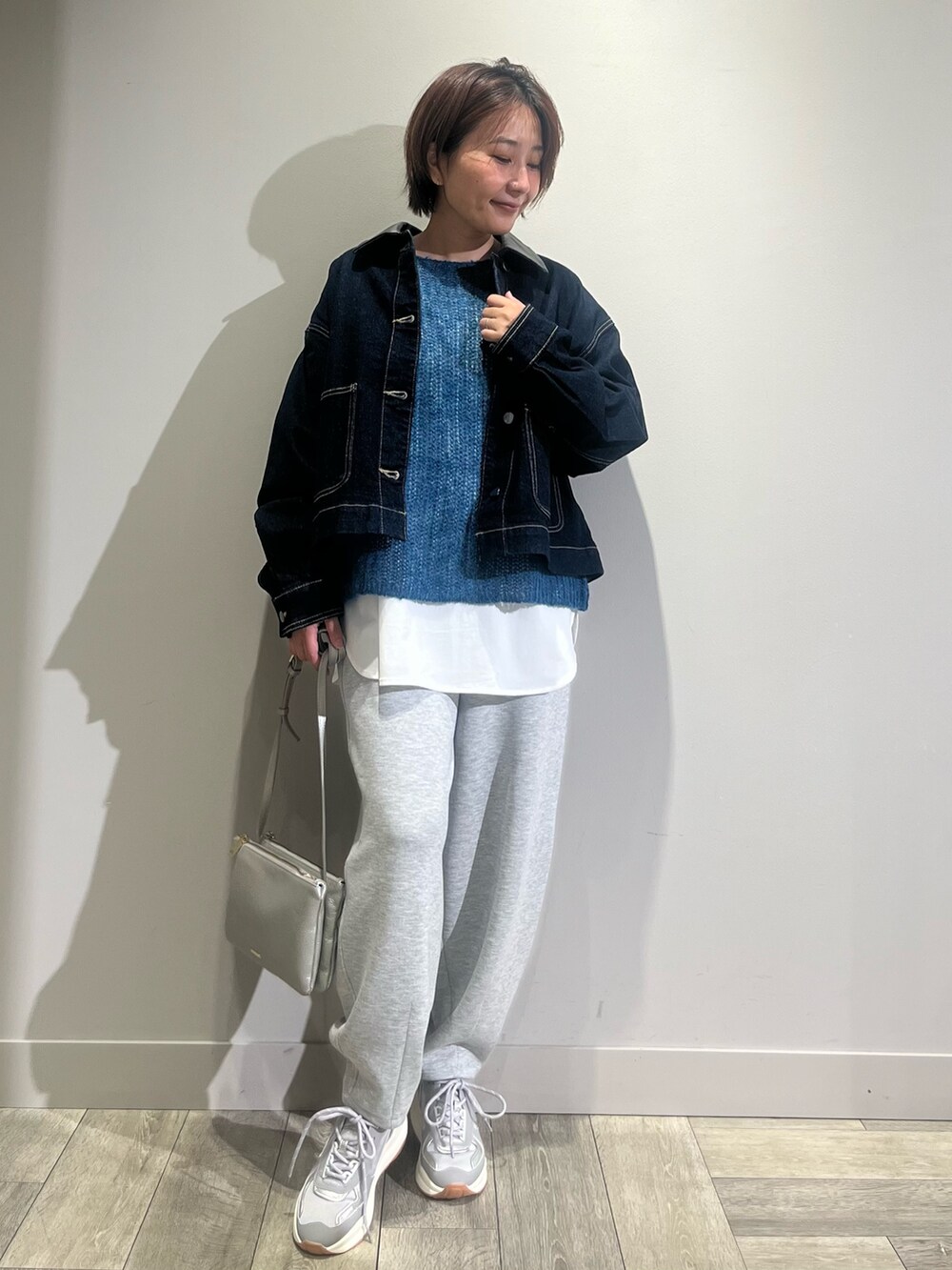 ホワイト系のTシャツ/カットソー、ブルー系のニット/セーター、ブルー系のデニムジャケットを着用したレディースの秋コーディネートの5枚目の写真