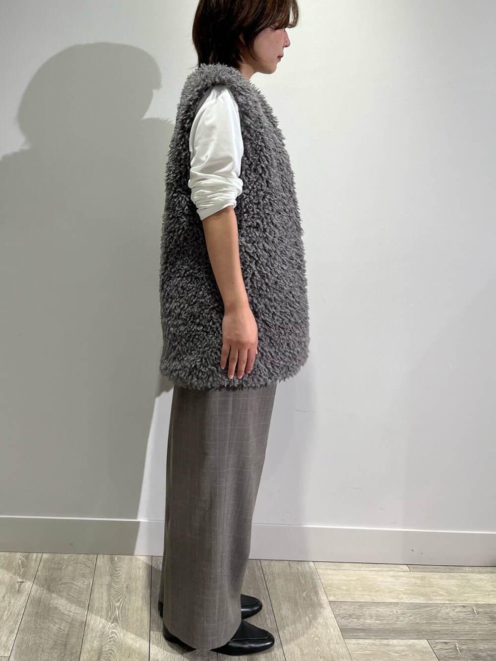 グレー系のベスト、ホワイト系のTシャツ/カットソー、ブラウン系のその他パンツを着用したレディースの秋コーディネートの4枚目の写真
