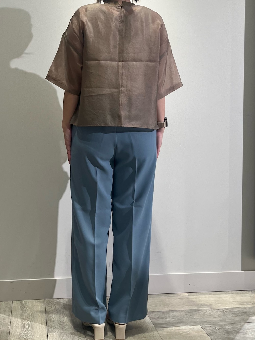 ブラウン系のシャツ/ブラウス、ホワイト系のタンクトップ、ブルー系のスラックスを着用したレディースの春コーディネートの4枚目の写真