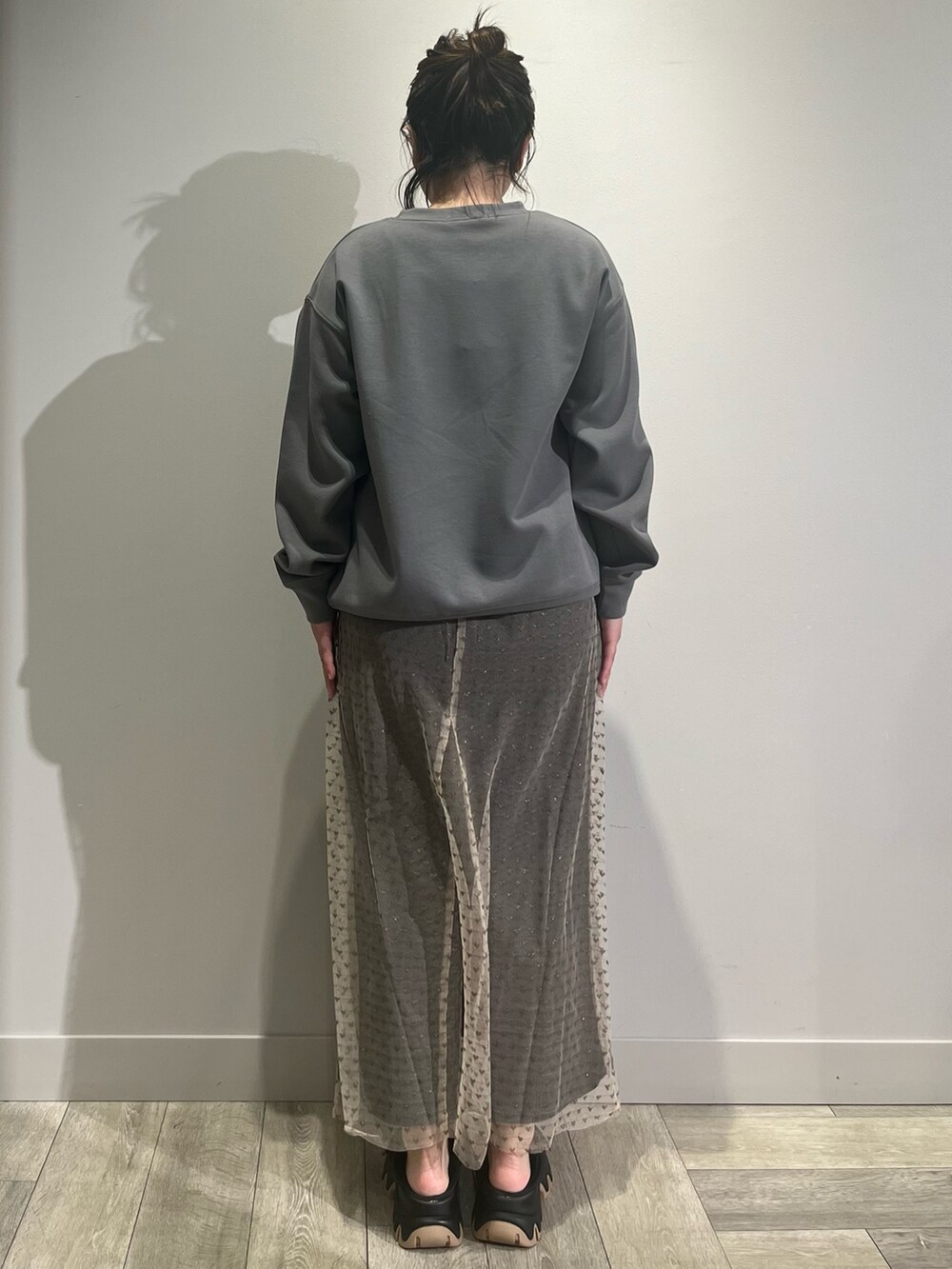 ブルー系のシャツ/ブラウス、ブラック系のスカート、ブラック系のスニーカーを着用したレディースの冬コーディネートの4枚目の写真