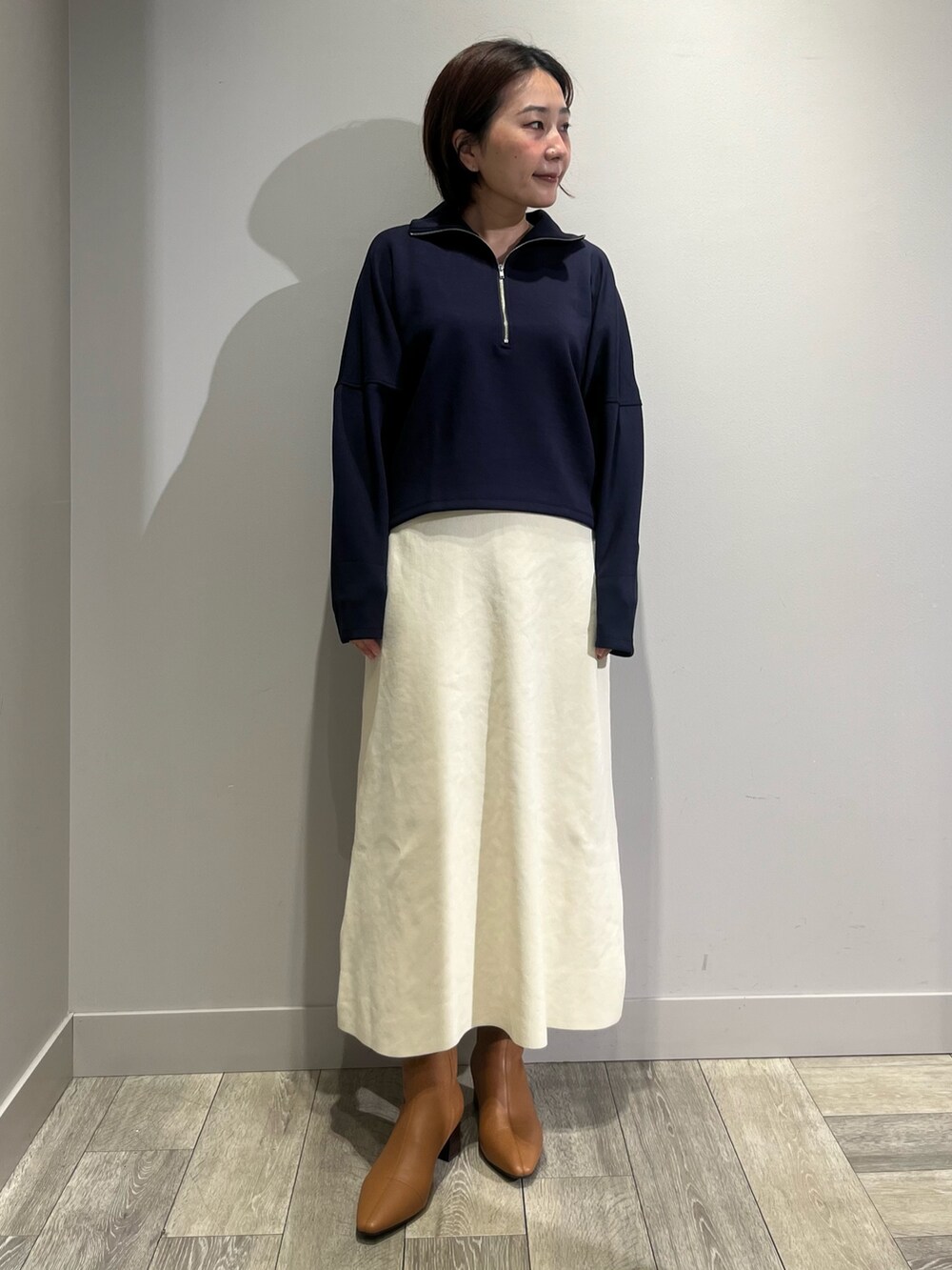 ブルー系のスウェット、ホワイト系のスカートを着用したレディースの秋コーディネートの2枚目の写真