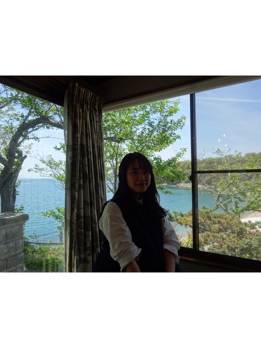 ホワイト系のシャツワンピース、ブルー系のトップス、ブラウン系のローファーを着用したレディースの夏コーディネートの3枚目の写真