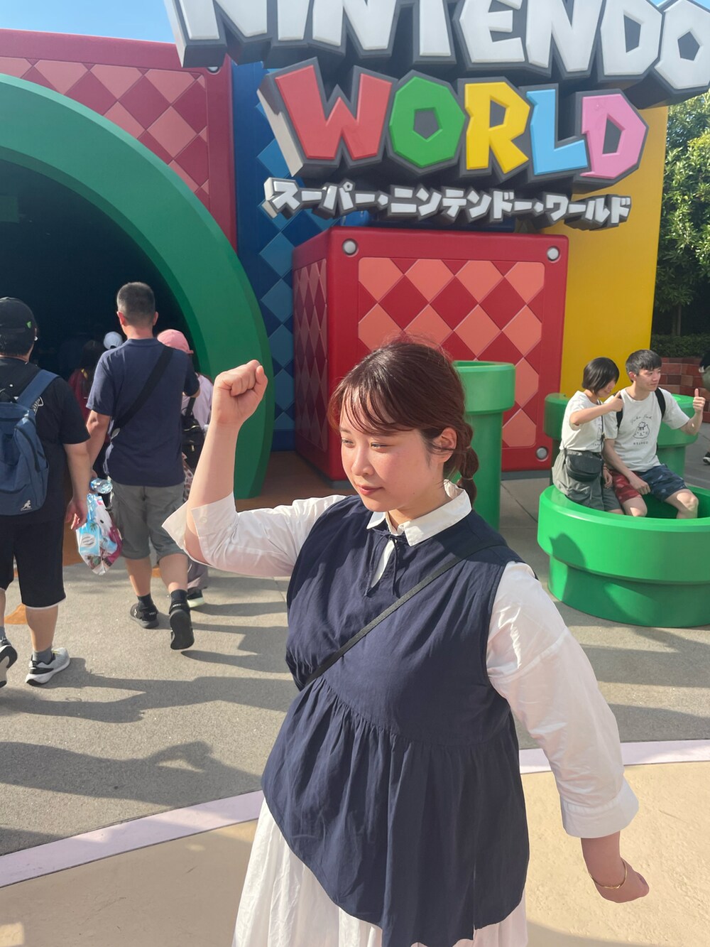 ブルー系のトップス、ホワイト系のシャツワンピースを着用したレディースの夏コーディネートの2枚目の写真