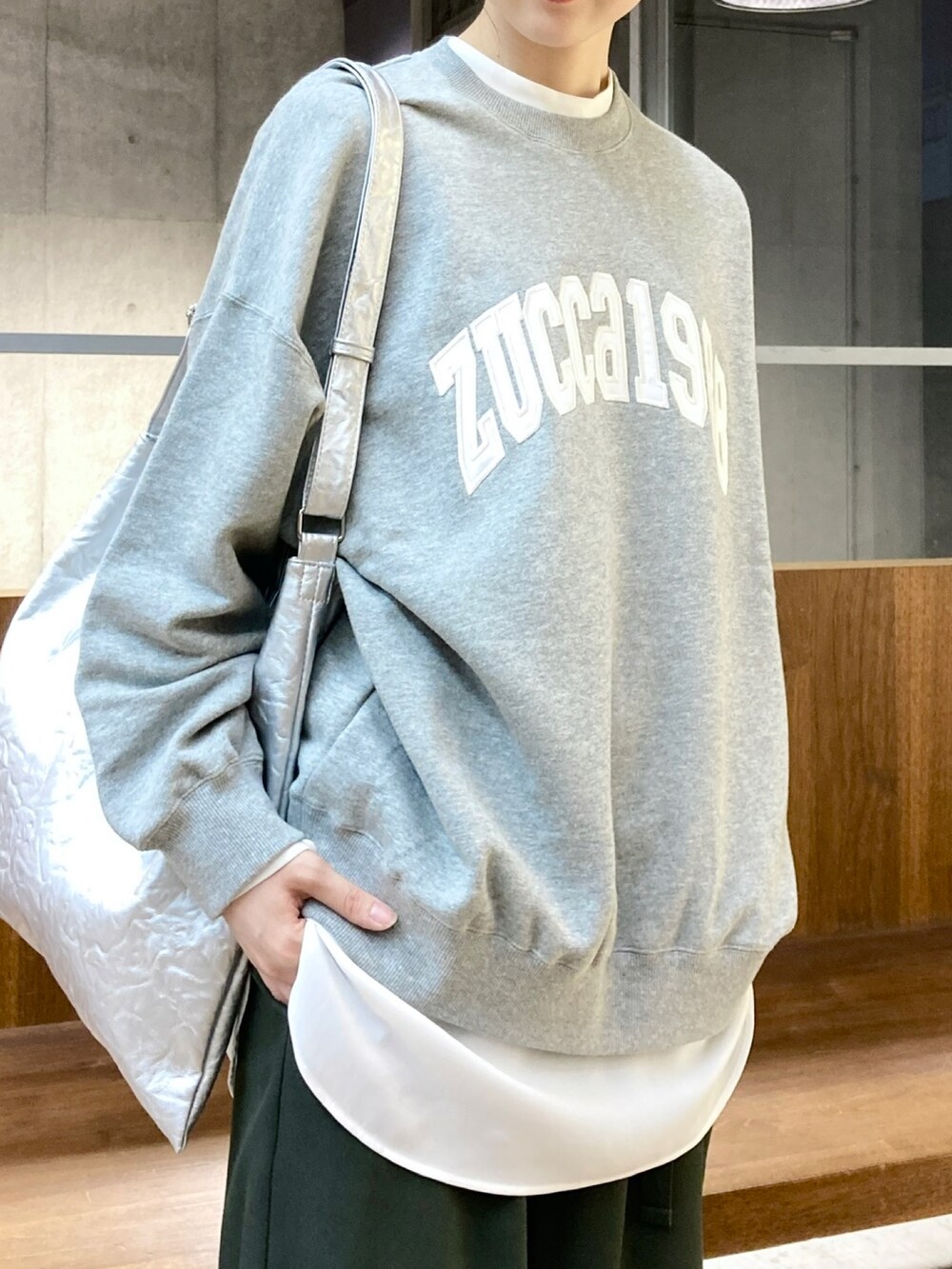 グレー系のスウェット、シルバー系のトートバッグ、グリーン系のその他パンツを着用したレディースの秋コーディネートの2枚目の写真