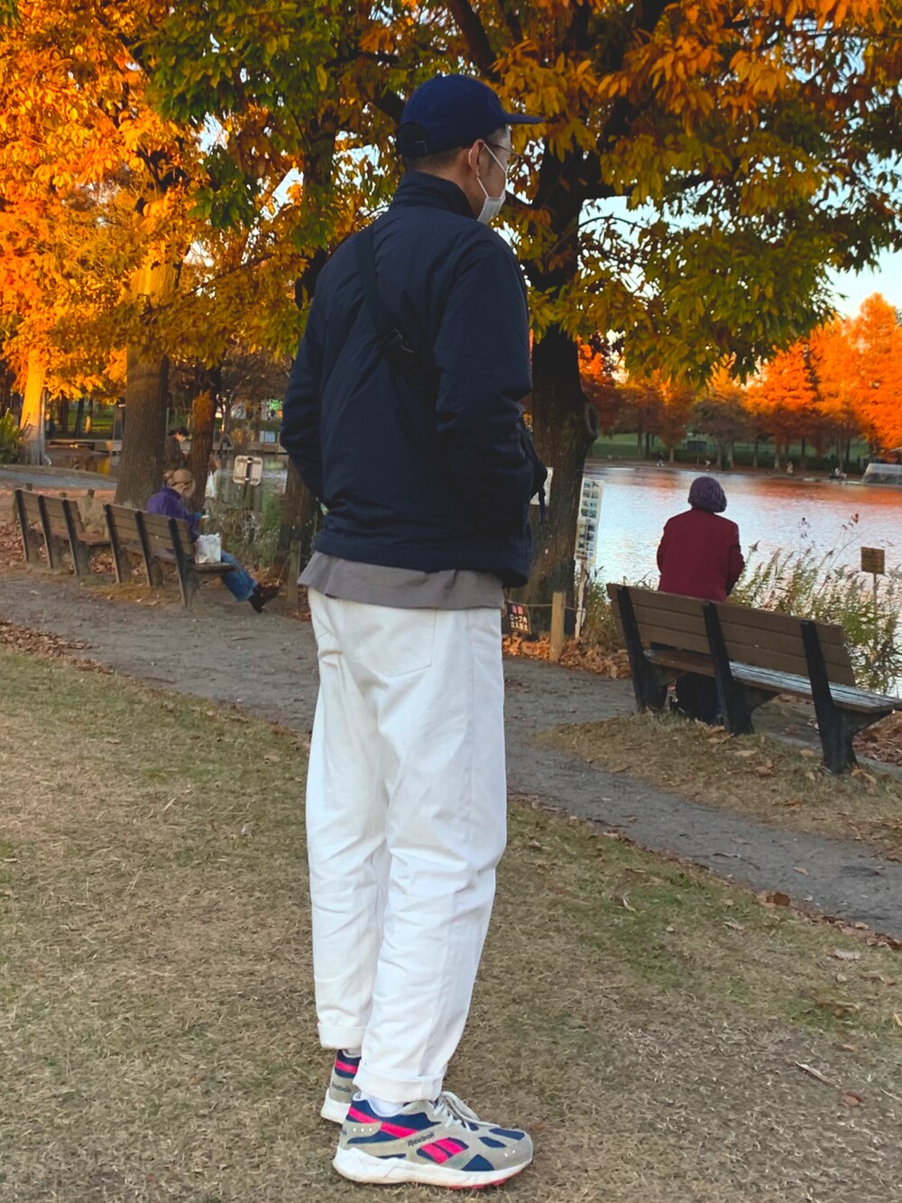 ブルー系のナイロンジャケット、ブルー系のデニムパンツ、ホワイト系のスニーカーを着用したメンズの秋コーディネートの4枚目の写真