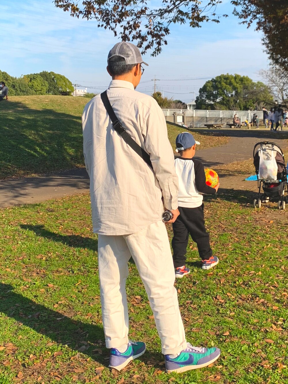 グリーン系のスニーカー、ブルー系のデニムパンツ、ホワイト系のシャツ/ブラウスを着用したメンズの秋コーディネートの2枚目の写真