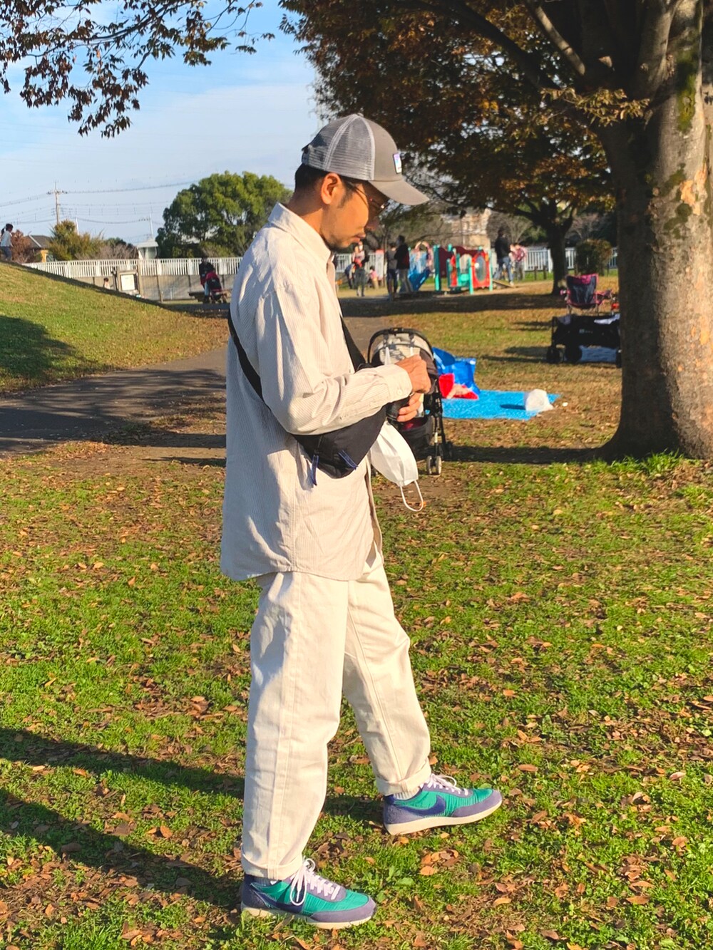 グリーン系のスニーカー、ブルー系のデニムパンツ、ホワイト系のシャツ/ブラウスを着用したメンズの秋コーディネートの3枚目の写真