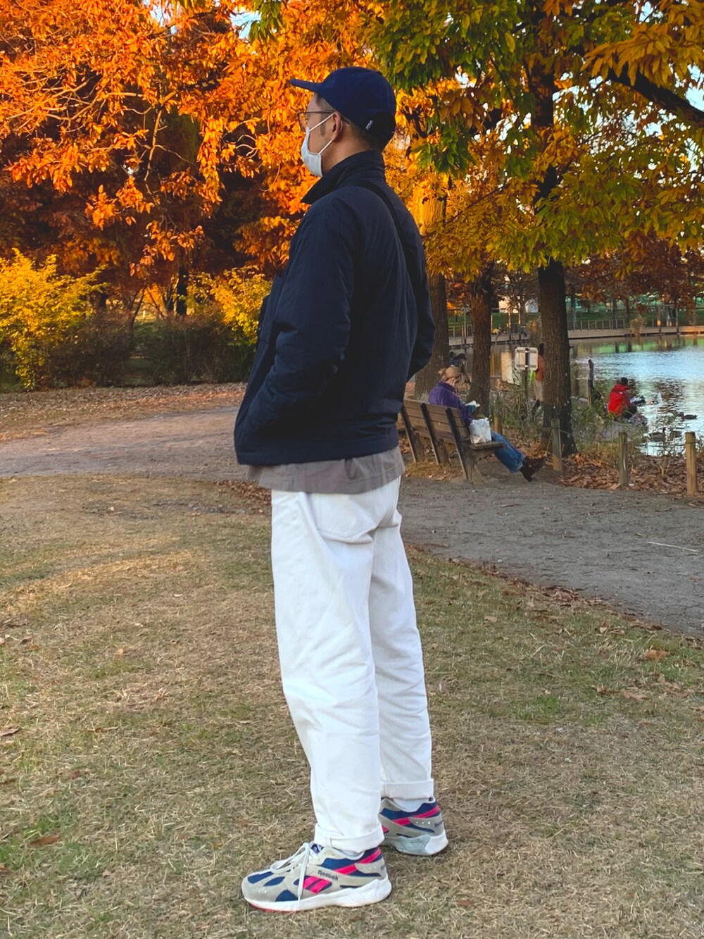 ブルー系のナイロンジャケット、ブルー系のデニムパンツ、ホワイト系のスニーカーを着用したメンズの秋コーディネートの3枚目の写真