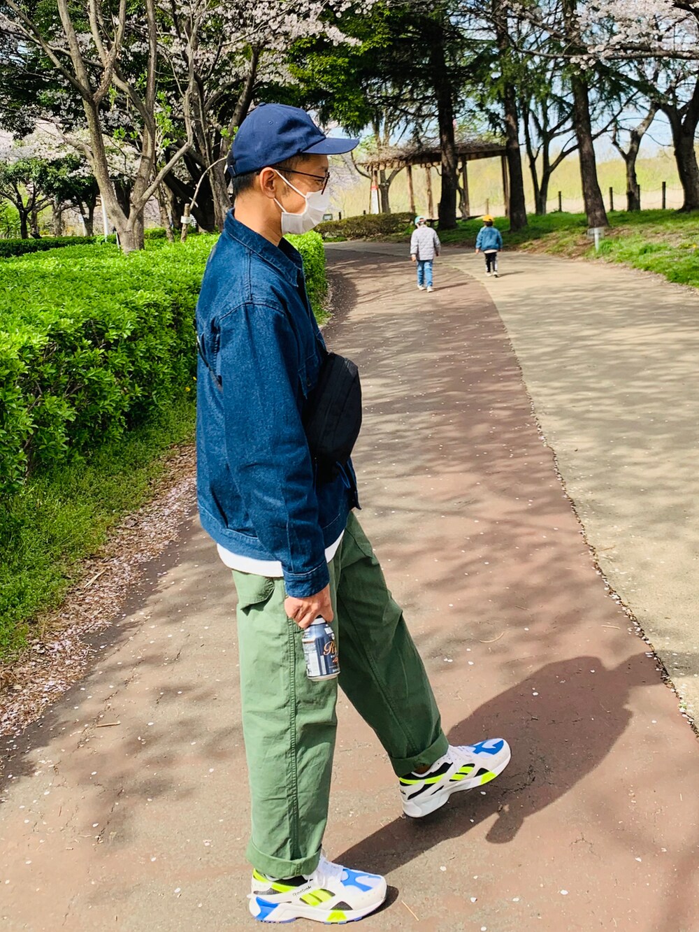 ブルー系のデニムジャケット、ブラック系のボディバッグ/ウエストポーチ、ブラウン系のその他パンツを着用したメンズの春コーディネートの2枚目の写真