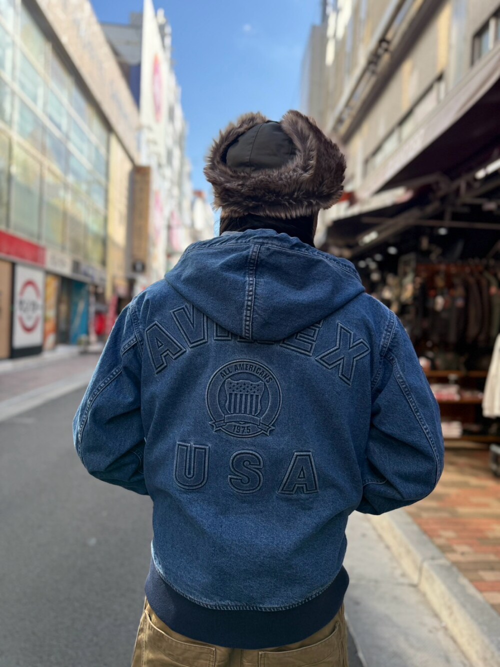 ブルー系のパーカー、グリーン系のキャップを着用したメンズの冬コーディネートの2枚目の写真