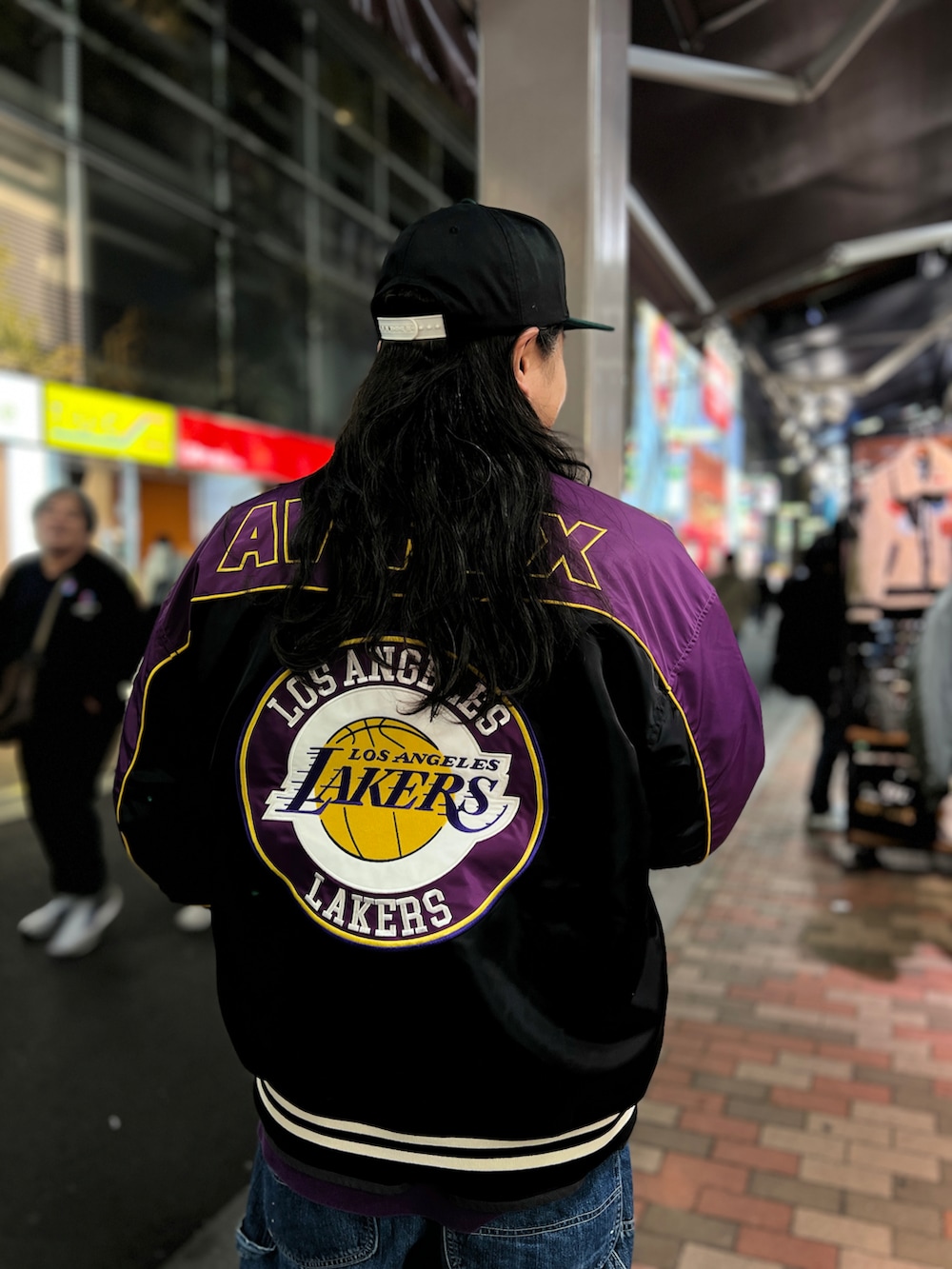 レッド系のジャケット/アウター、ブラック系のキャップを着用したメンズの冬コーディネートの2枚目の写真