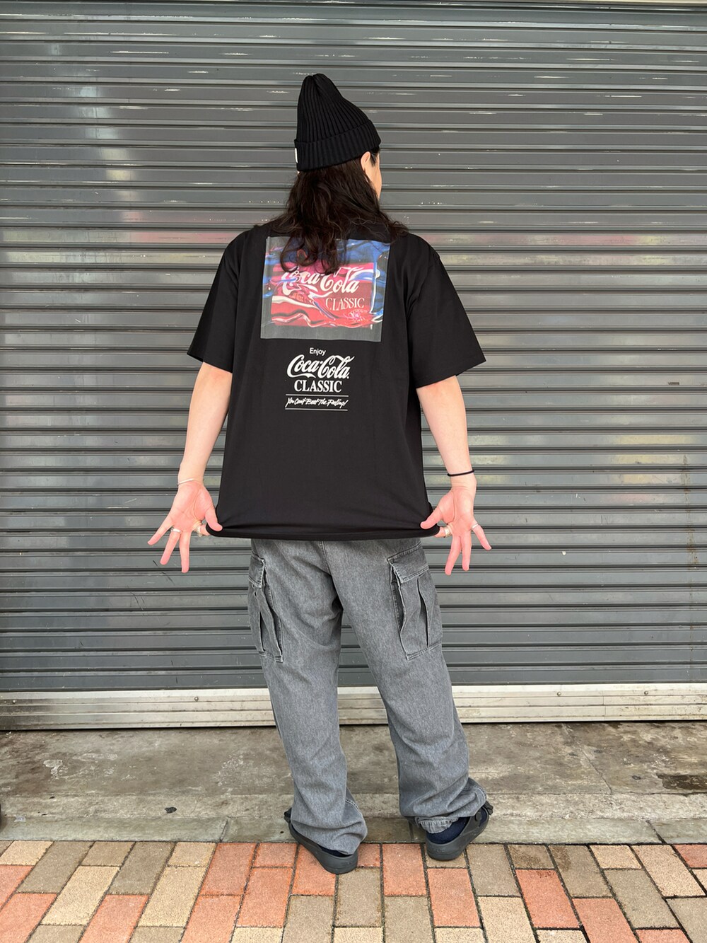 ブラック系のTシャツ/カットソー、ブラック系のカーゴパンツ、ブラック系のサンダルを着用したメンズの夏コーディネートの2枚目の写真