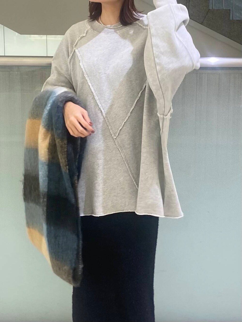 ブラック系のブーツ、ブラック系のスカート、グレー系のTシャツ/カットソーを着用したレディースの秋コーディネートの3枚目の写真