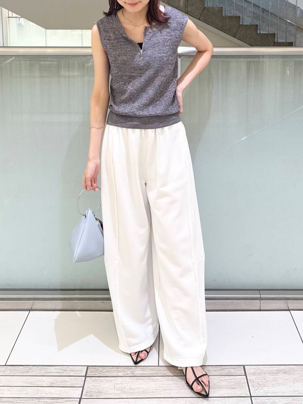 ブルー系のハンドバッグ、ブラック系のキャミソール、ブラック系のサンダルを着用したレディースの夏コーディネートの2枚目の写真