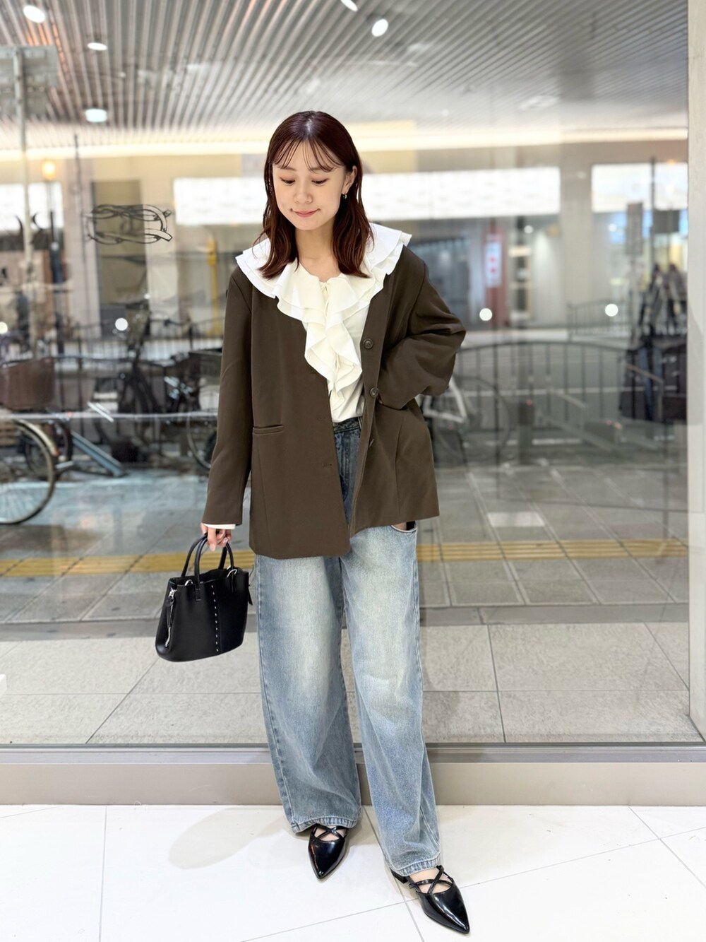 ブラウン系のその他アウター、ホワイト系のシャツ/ブラウス、ブルー系のデニムパンツを着用したレディースの秋コーディネートの2枚目の写真