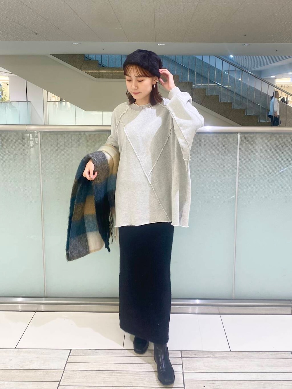 ブラック系のブーツ、ブラック系のスカート、グレー系のTシャツ/カットソーを着用したレディースの秋コーディネートの2枚目の写真