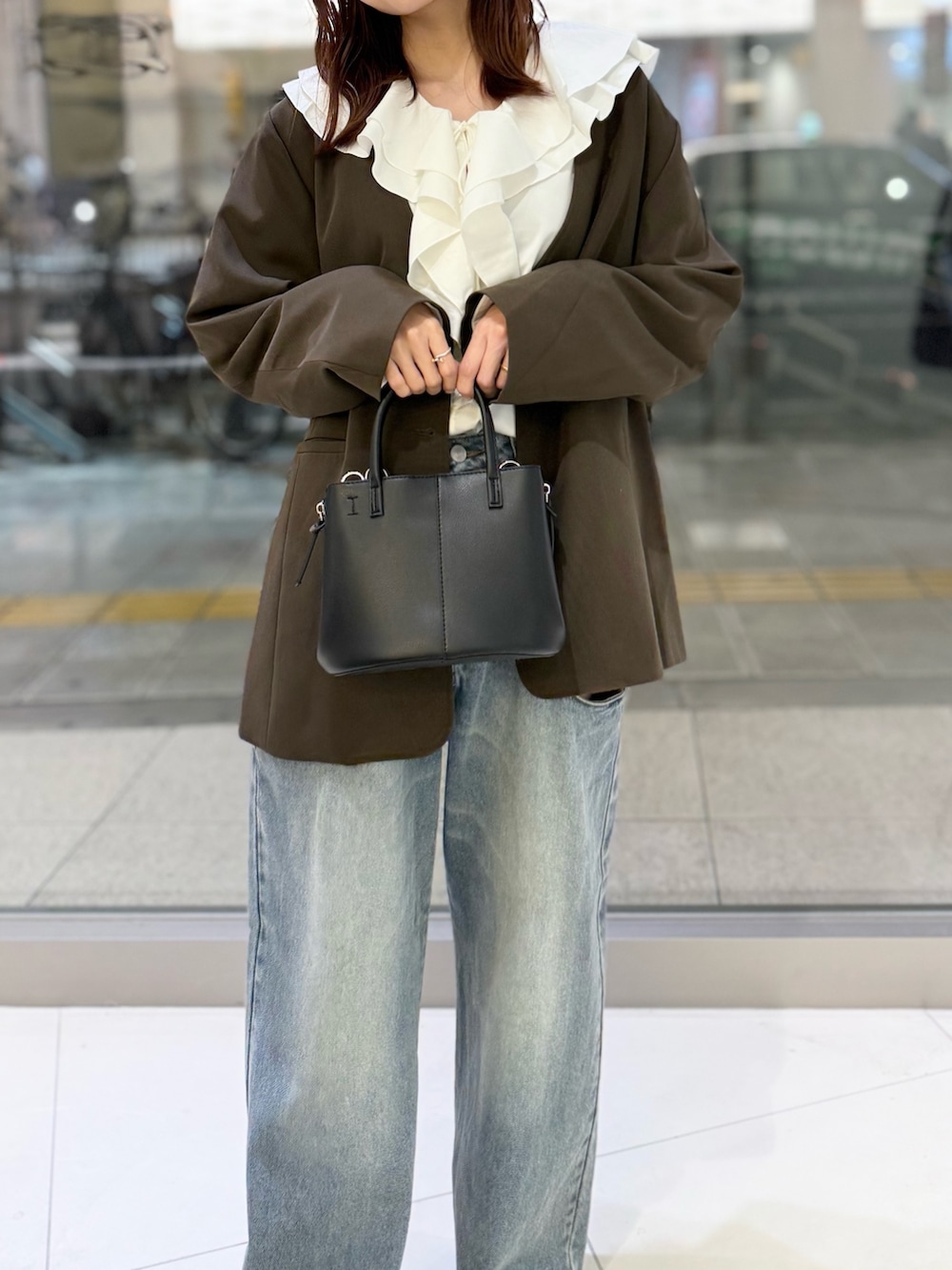 ブラウン系のその他アウター、ホワイト系のシャツ/ブラウス、ブルー系のデニムパンツを着用したレディースの秋コーディネートの3枚目の写真