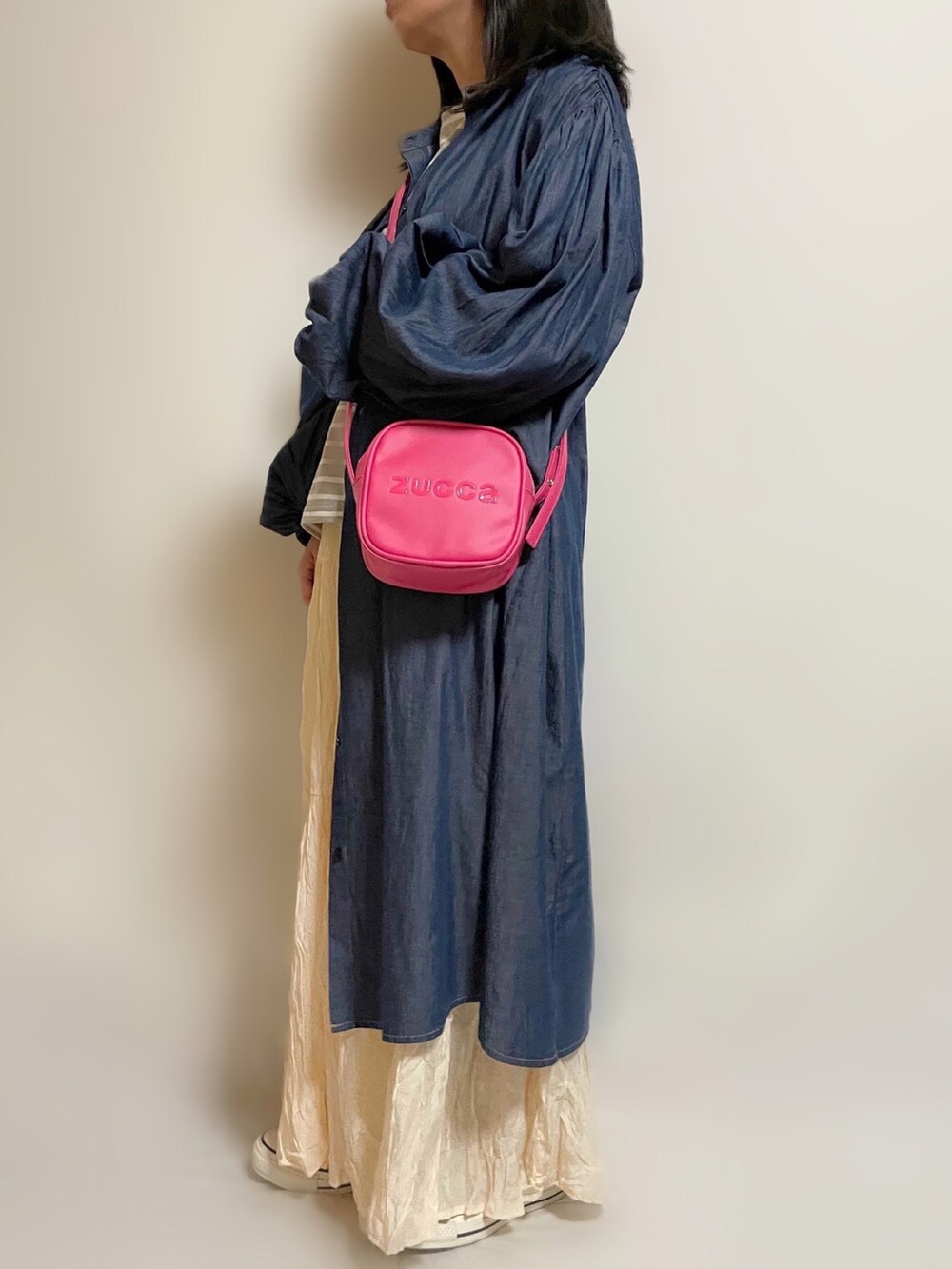 ブルー系のワンピース、ピンク系のショルダーバッグ、ホワイト系のスカートを着用したレディースの春コーディネートの2枚目の写真