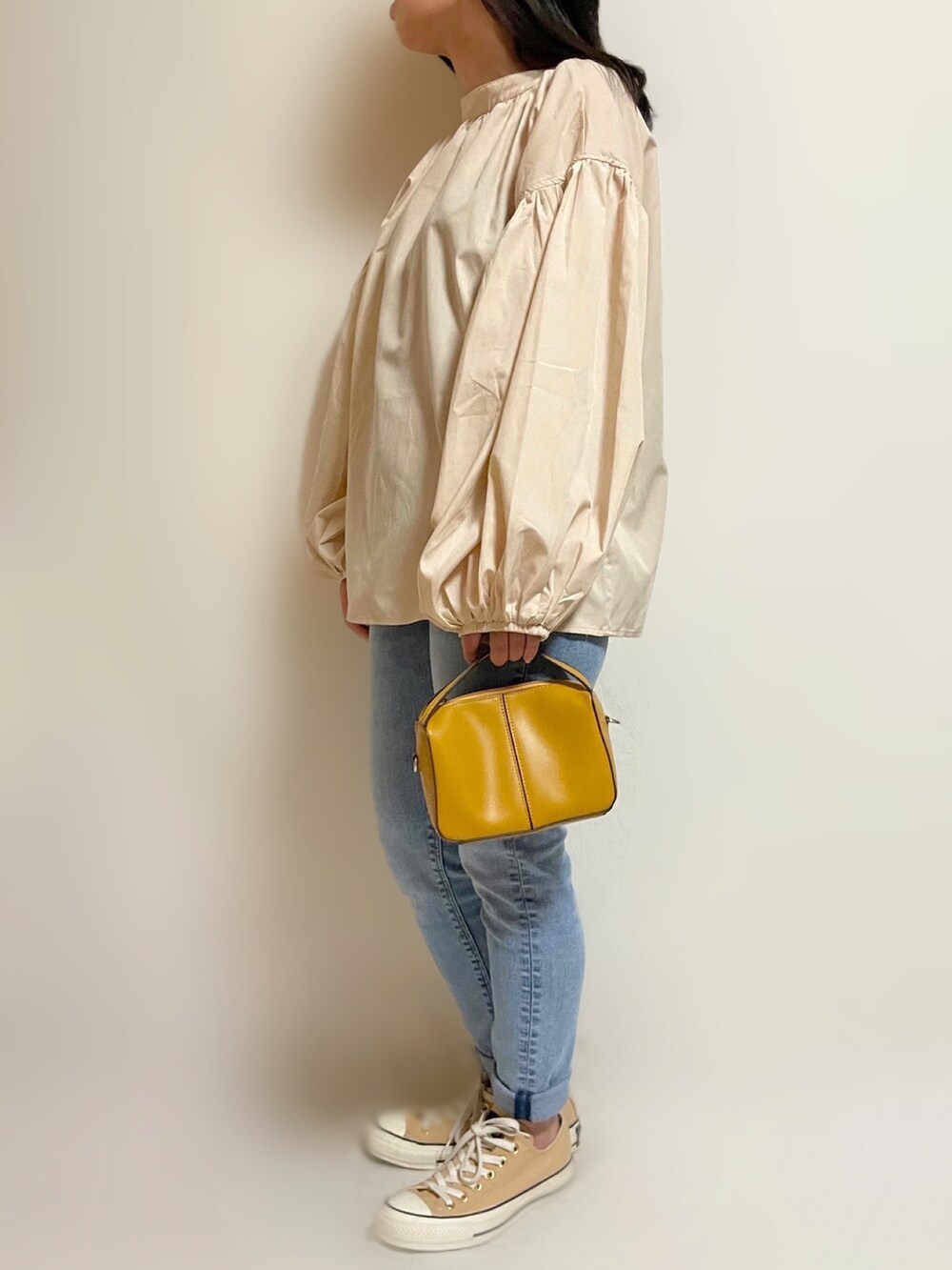 ブルー系のデニムパンツ、ベージュ系のシャツ/ブラウス、イエロー系のショルダーバッグを着用したレディースの春コーディネートの2枚目の写真