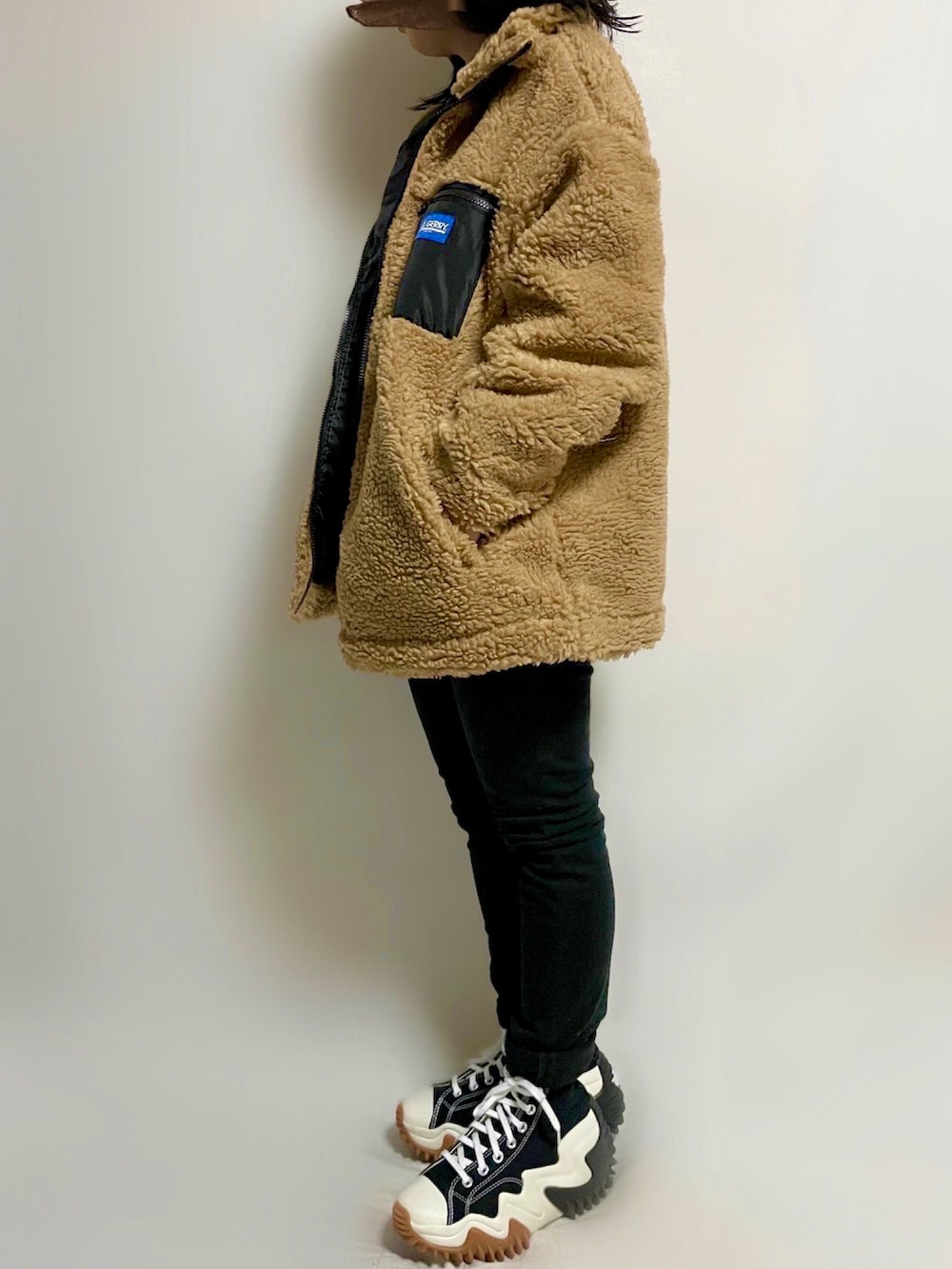 ベージュ系のブルゾン、ホワイト系のスウェット、ブラック系のパンツを着用したレディースの冬コーディネートの2枚目の写真