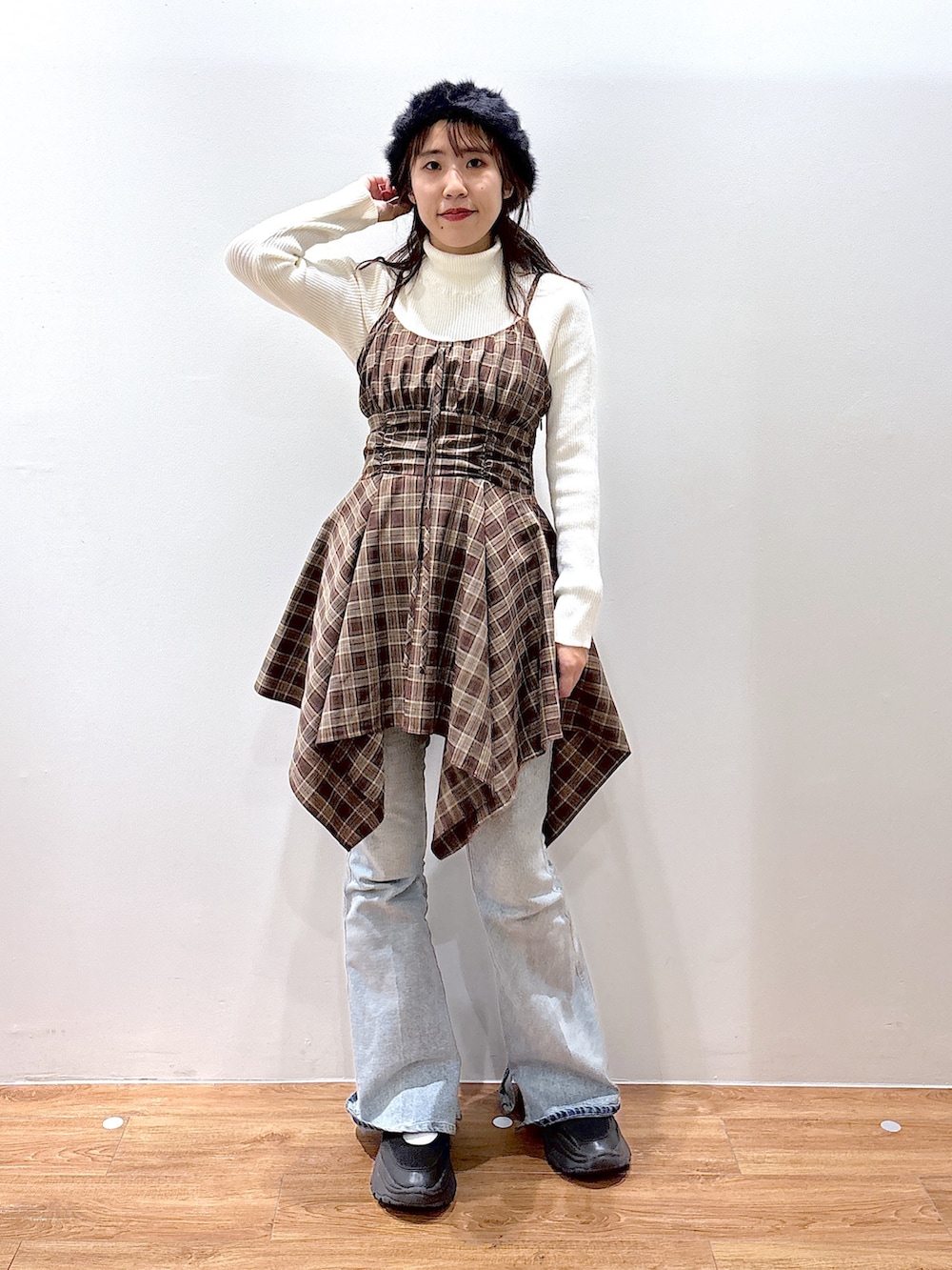 ブラウン系のワンピース、ホワイト系のニット/セーター、ブルー系のデニムパンツを着用したレディースの秋コーディネートの2枚目の写真