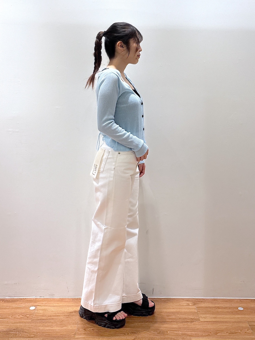 ホワイト系のデニムパンツ、ブルー系のニット/セーターを着用したレディースの春コーディネートの3枚目の写真