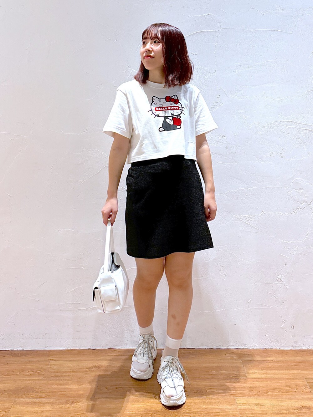 ホワイト系のハンドバッグ、ホワイト系のサンダル、ホワイト系のTシャツ/カットソーを着用したレディースの夏コーディネートの2枚目の写真
