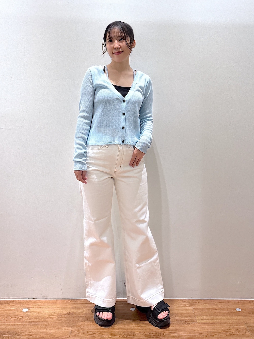 ホワイト系のデニムパンツ、ブルー系のニット/セーターを着用したレディースの春コーディネートの2枚目の写真