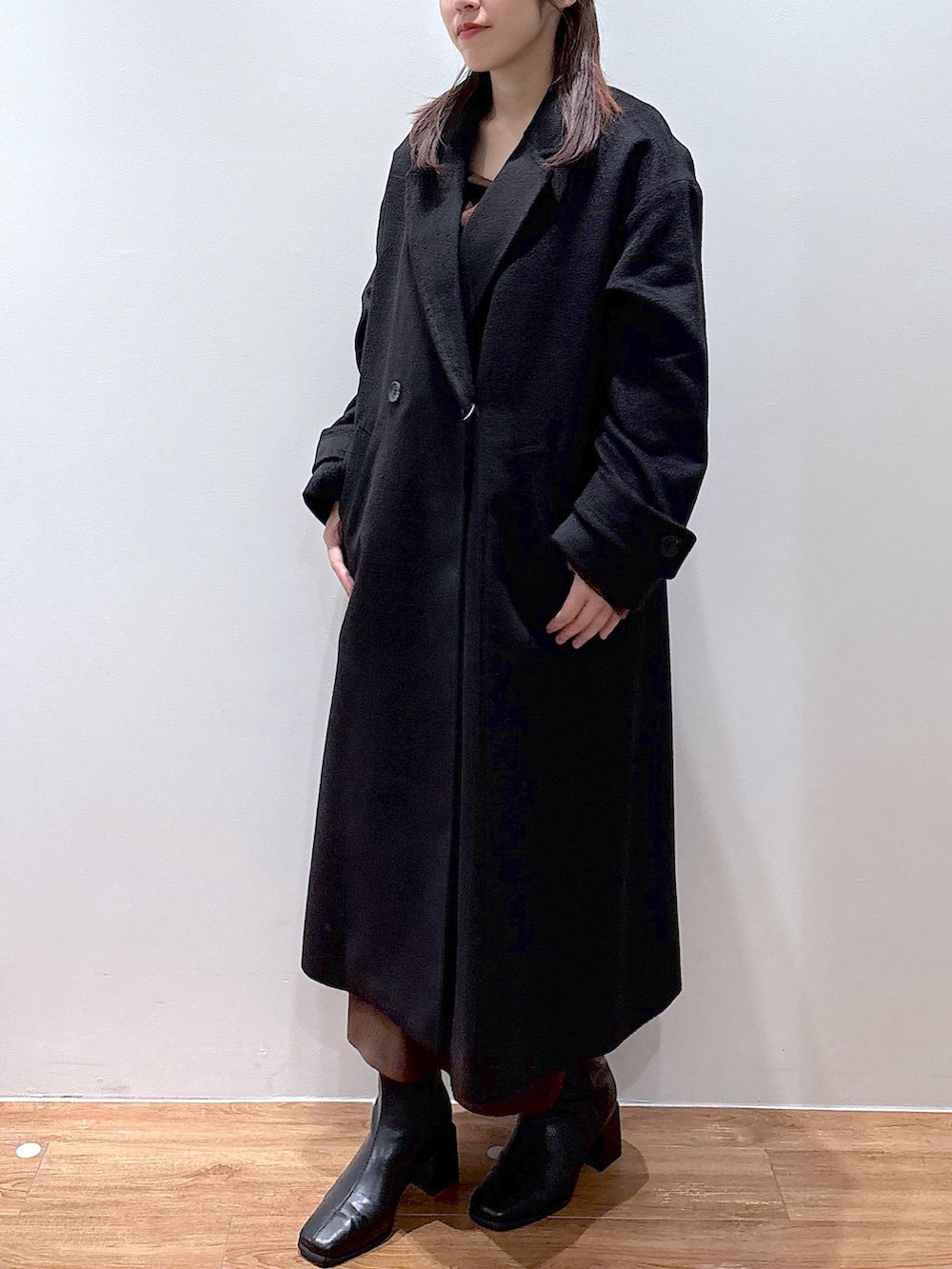 ブラウン系のワンピース、ブラック系のチェスターコートを着用したレディースの秋コーディネートの3枚目の写真