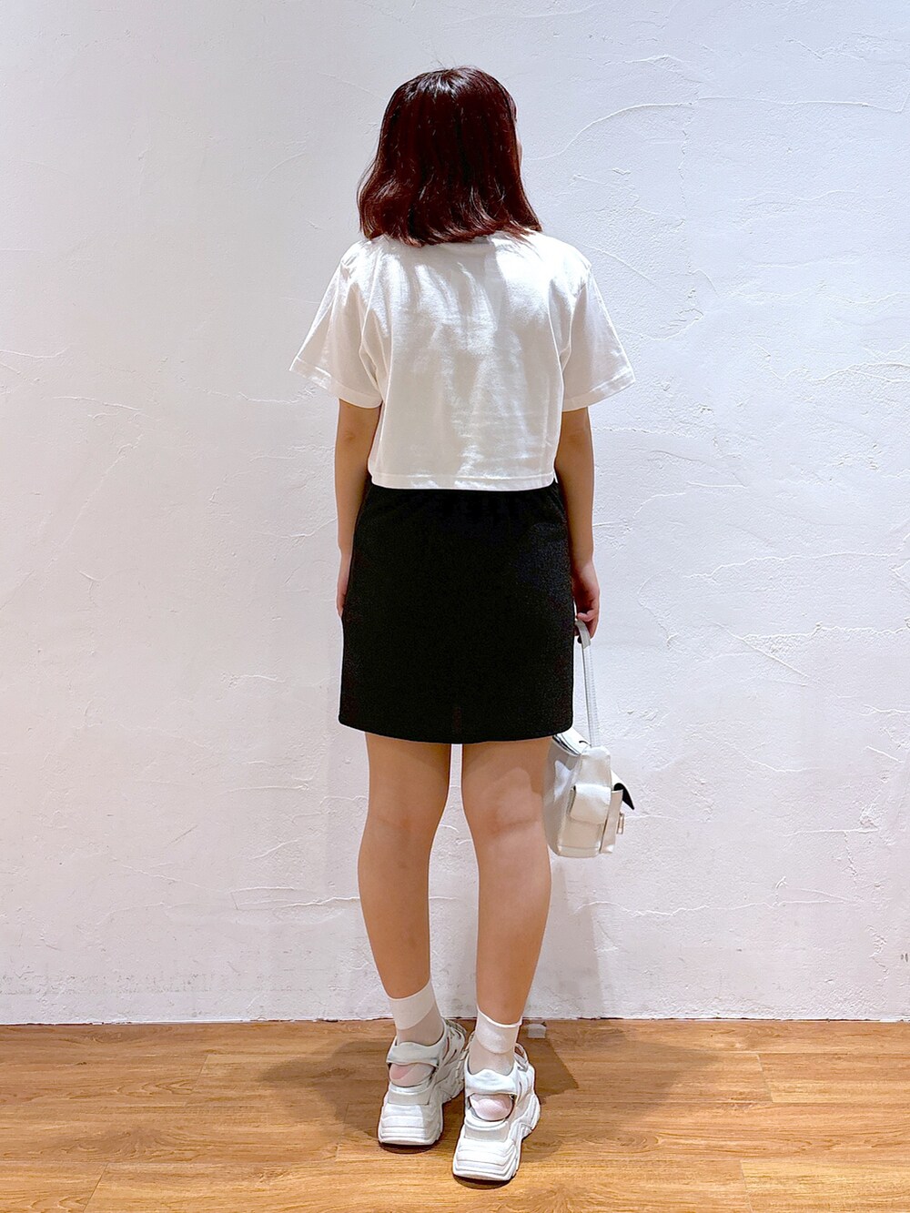 ホワイト系のハンドバッグ、ホワイト系のサンダル、ホワイト系のTシャツ/カットソーを着用したレディースの夏コーディネートの5枚目の写真