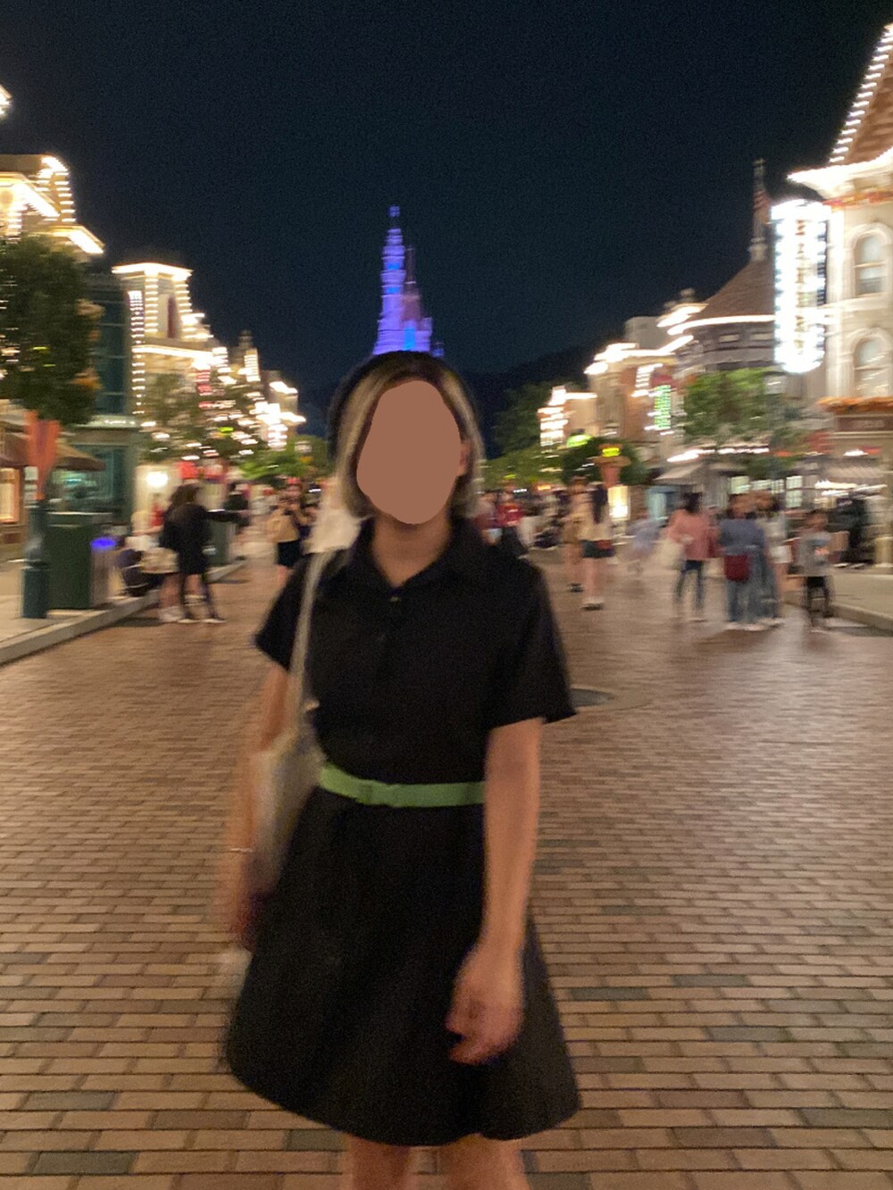 ブラック系のチュニック、ホワイト系のショルダーバッグ、ホワイト系のスニーカーを着用したレディースの春コーディネートの2枚目の写真