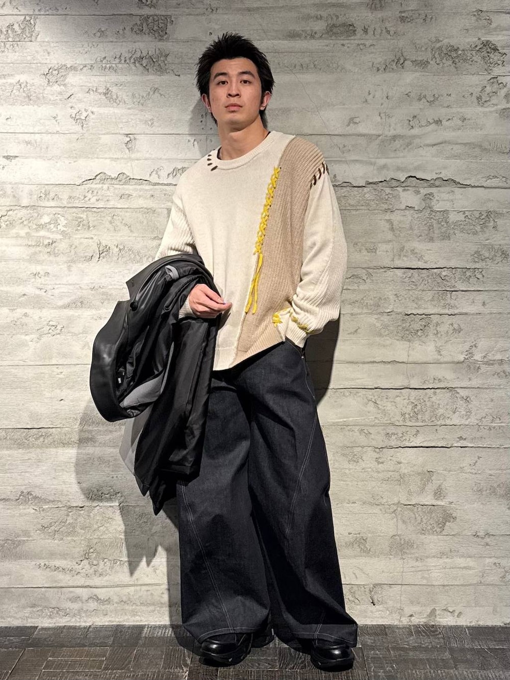 グレー系のトレンチコート、ブラック系のスニーカー、ホワイト系のニット/セーターを着用したメンズの秋コーディネートの5枚目の写真