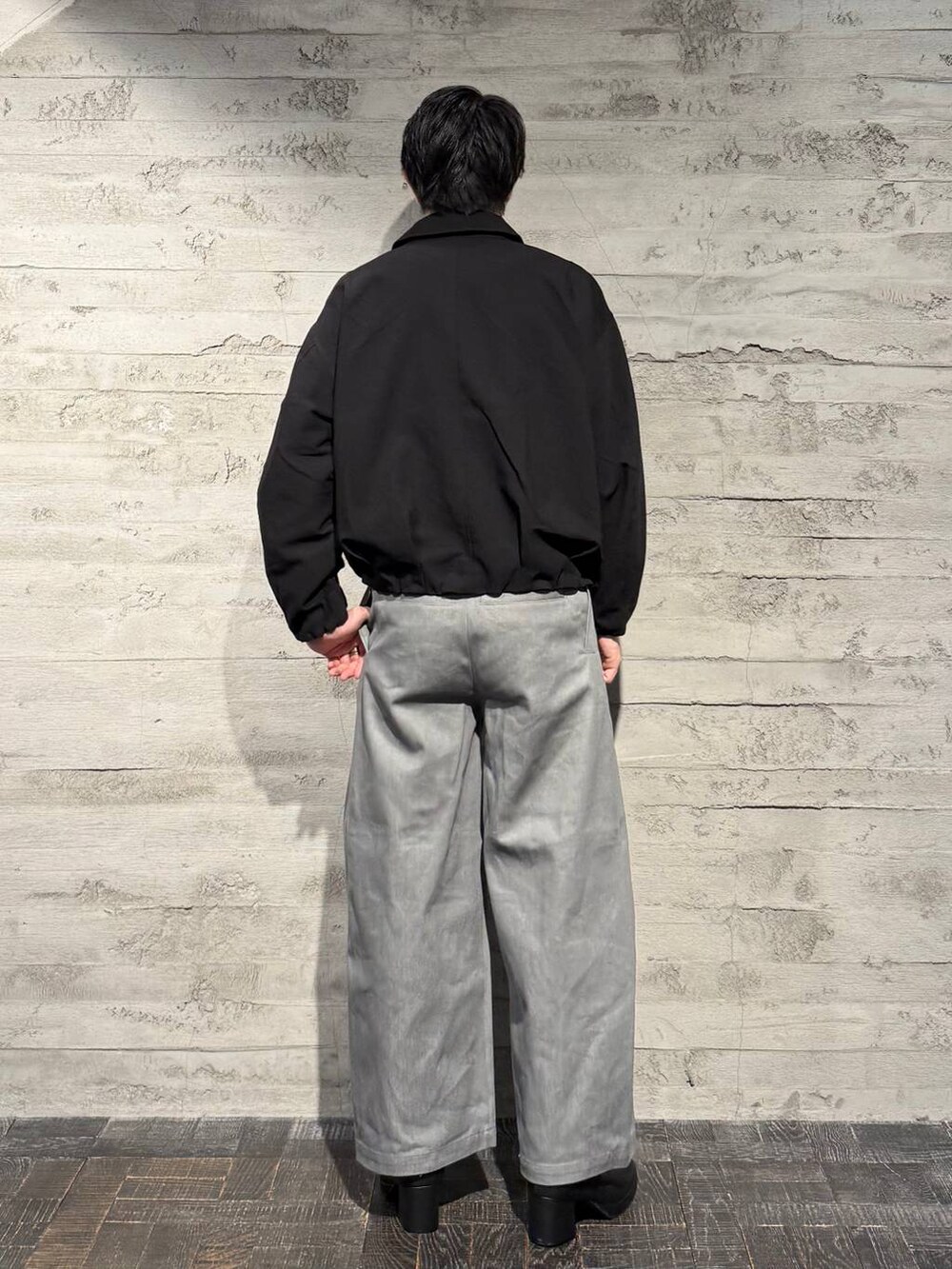 ブラック系のブーツ、ブラック系のブルゾン、グレー系のデニムパンツを着用したメンズの秋コーディネートの3枚目の写真