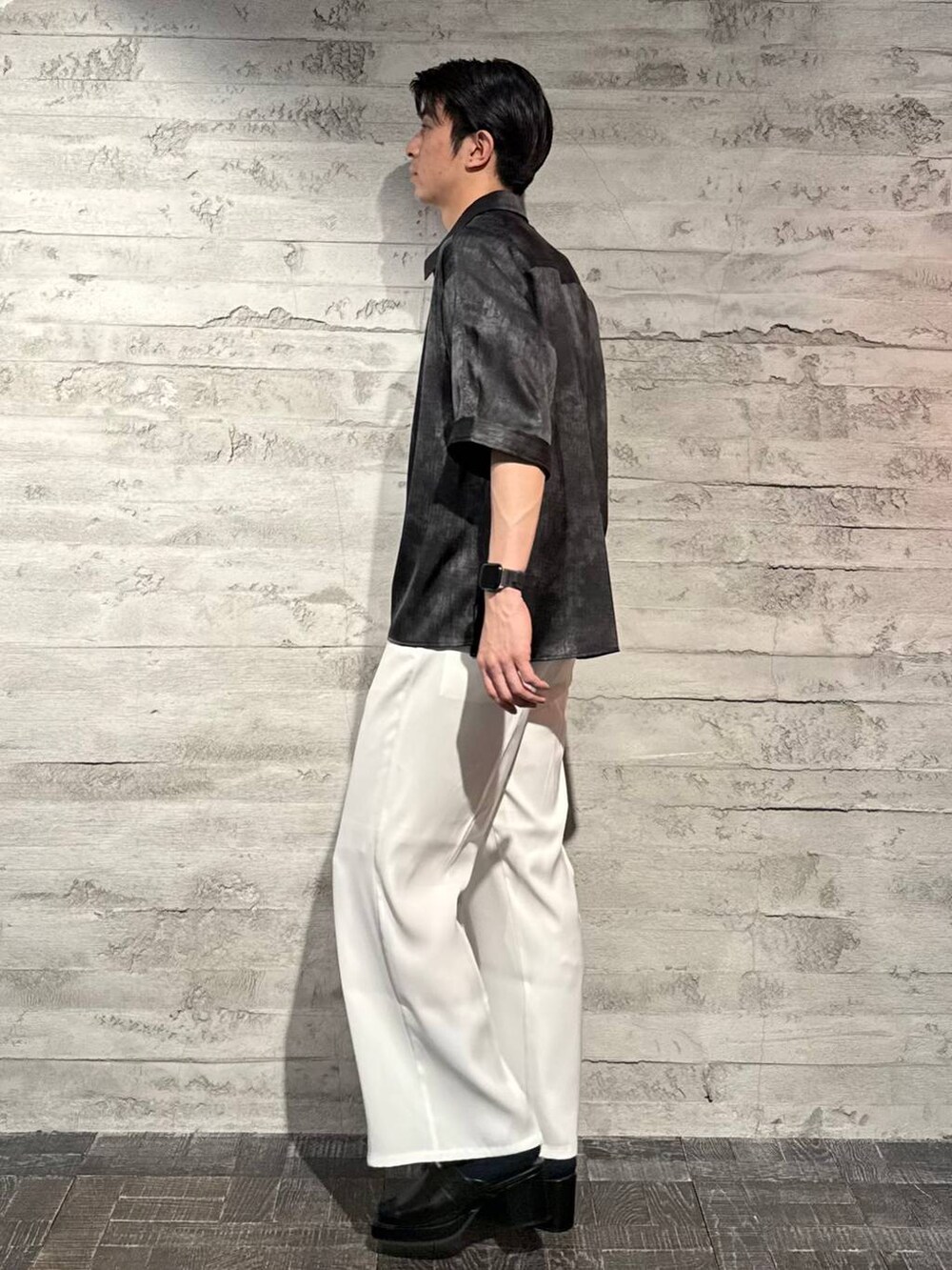 ホワイト系のスラックス、ブラック系のサンダル、グレー系のシャツ/ブラウスを着用したメンズの春コーディネートの2枚目の写真