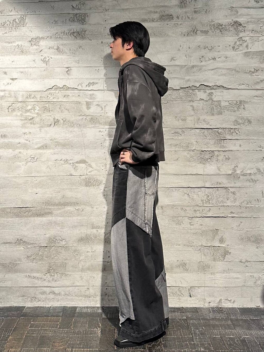 ブラック系のデニムパンツ、ブラック系のブーツ、ブラック系のパーカーを着用したメンズの秋コーディネートの2枚目の写真