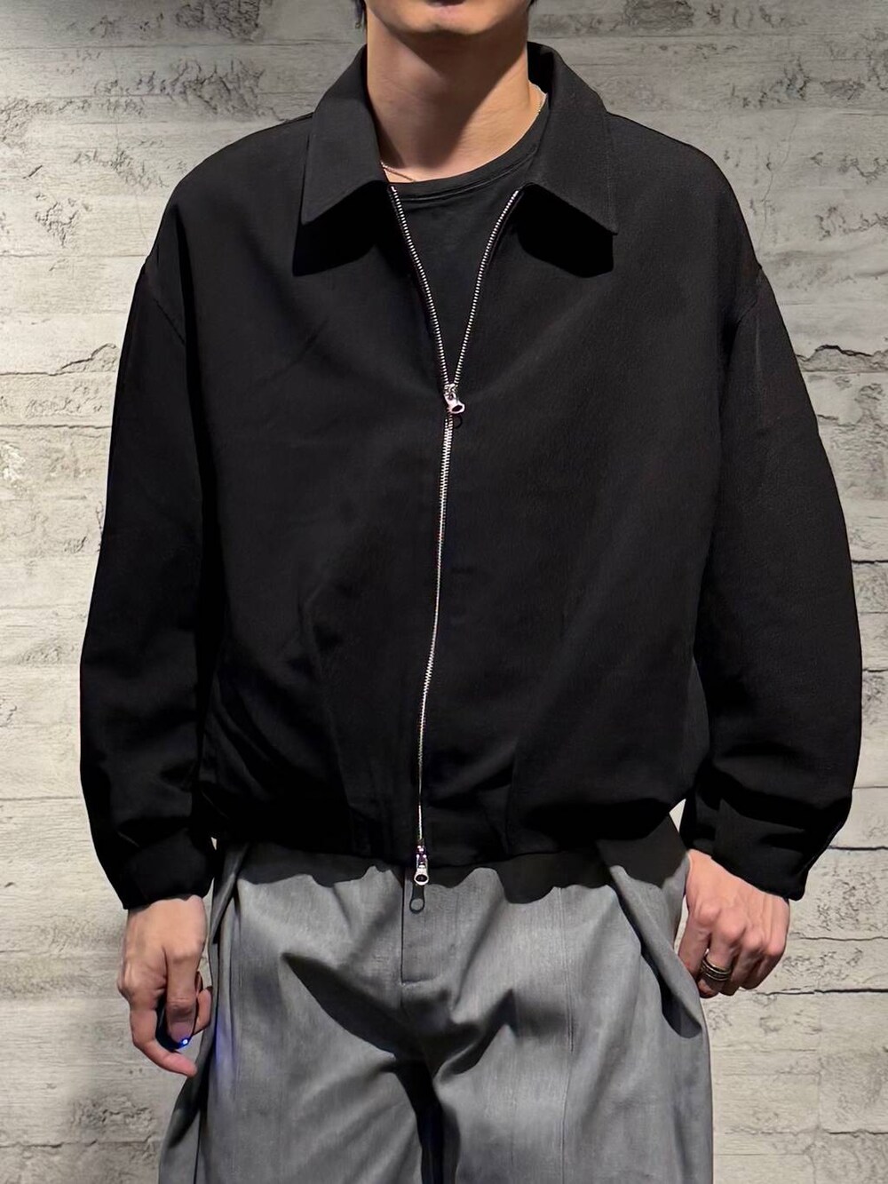 ブラック系のブーツ、ブラック系のブルゾン、グレー系のデニムパンツを着用したメンズの秋コーディネートの4枚目の写真