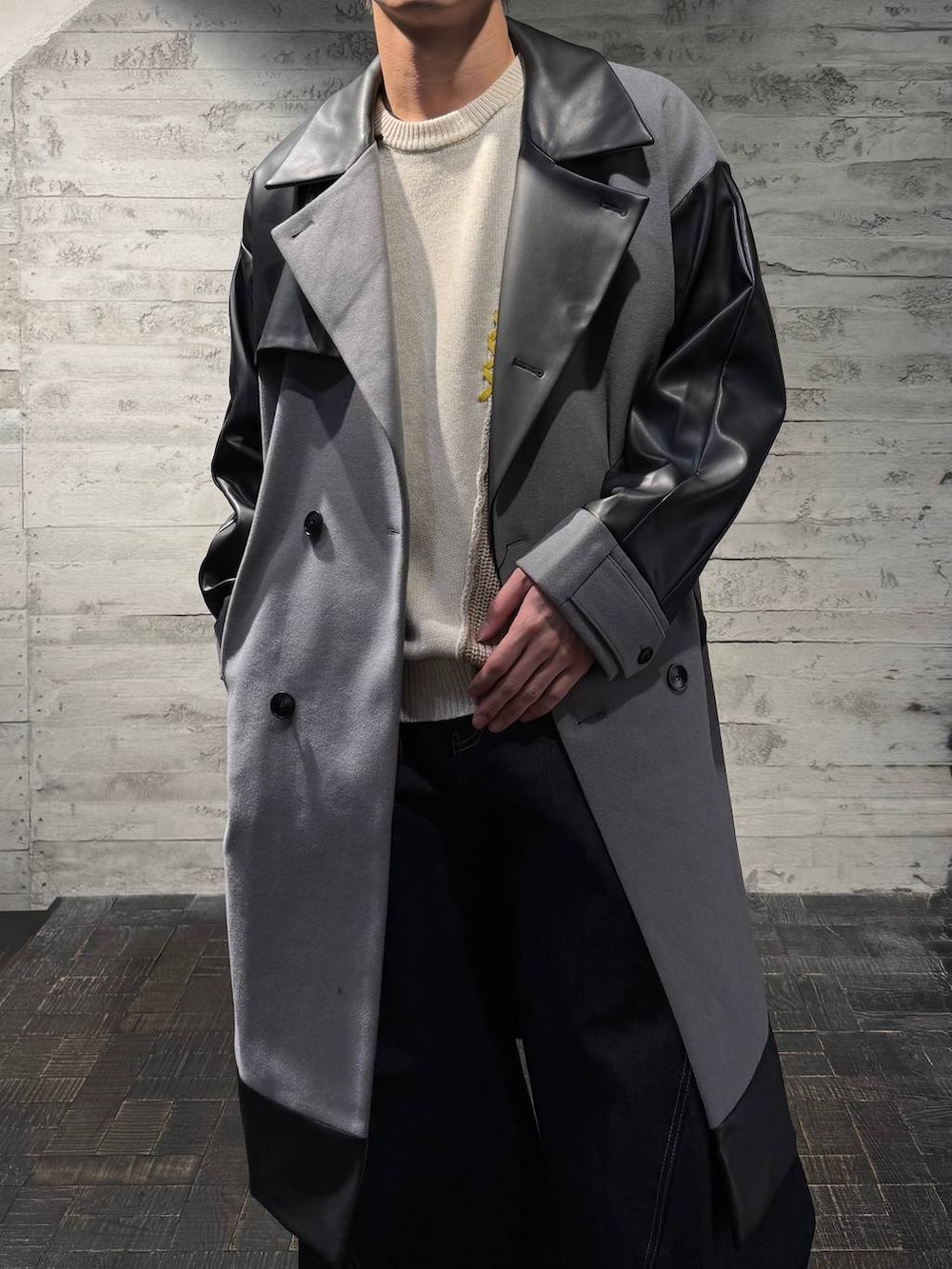 グレー系のトレンチコート、ブラック系のスニーカー、ホワイト系のニット/セーターを着用したメンズの秋コーディネートの4枚目の写真