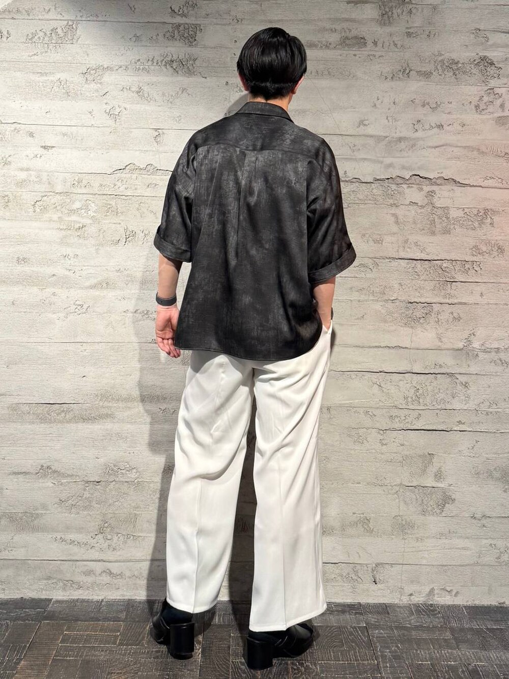 ホワイト系のスラックス、ブラック系のサンダル、グレー系のシャツ/ブラウスを着用したメンズの春コーディネートの3枚目の写真