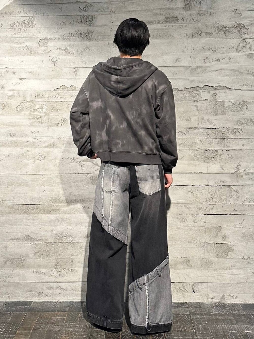 ブラック系のデニムパンツ、ブラック系のブーツ、ブラック系のパーカーを着用したメンズの秋コーディネートの3枚目の写真