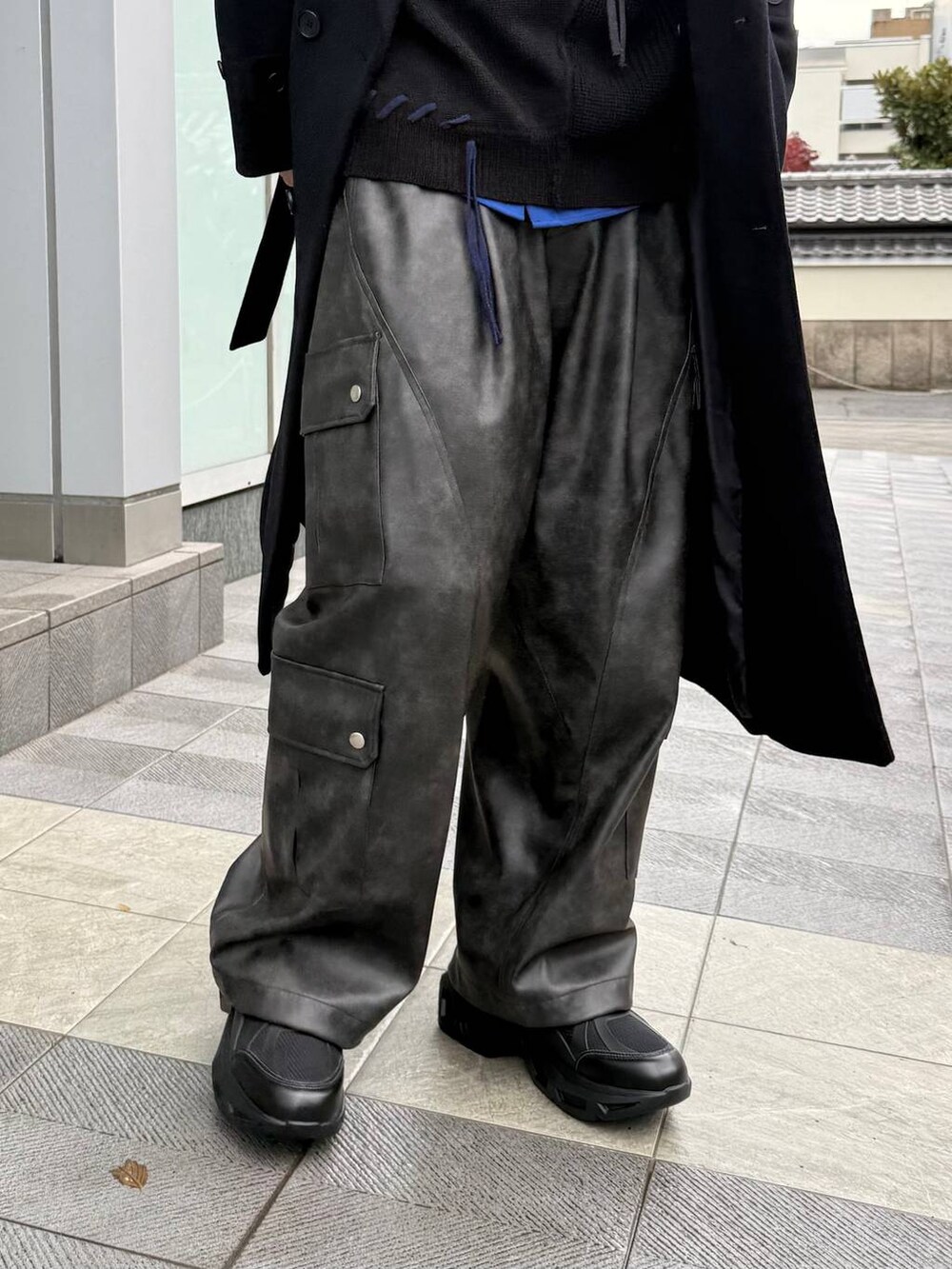 ブラック系のチェスターコート、グレー系のカーゴパンツ、ブラック系のスニーカーを着用したメンズの冬コーディネートの3枚目の写真