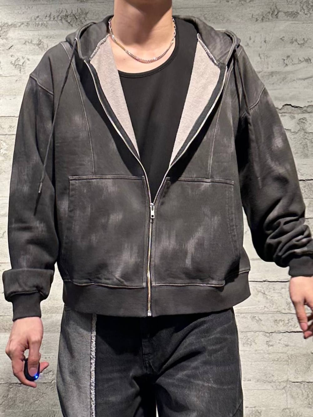 ブラック系のデニムパンツ、ブラック系のブーツ、ブラック系のパーカーを着用したメンズの秋コーディネートの4枚目の写真