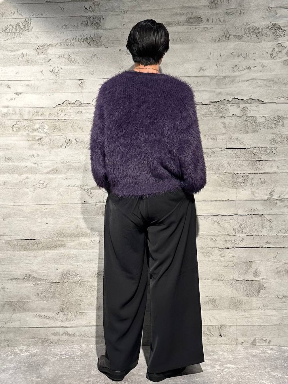 パープル系のニット/セーター、ブラック系のスラックス、ブラック系のブーツを着用したメンズの秋コーディネートの3枚目の写真