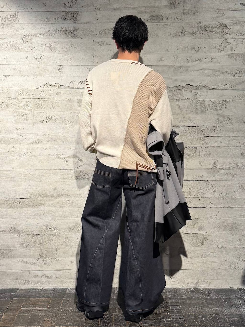 グレー系のトレンチコート、ブラック系のスニーカー、ホワイト系のニット/セーターを着用したメンズの秋コーディネートの7枚目の写真